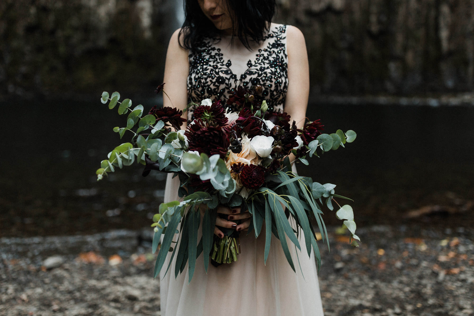 Bride holds her bouquet at Abiqua Falls in Oregon