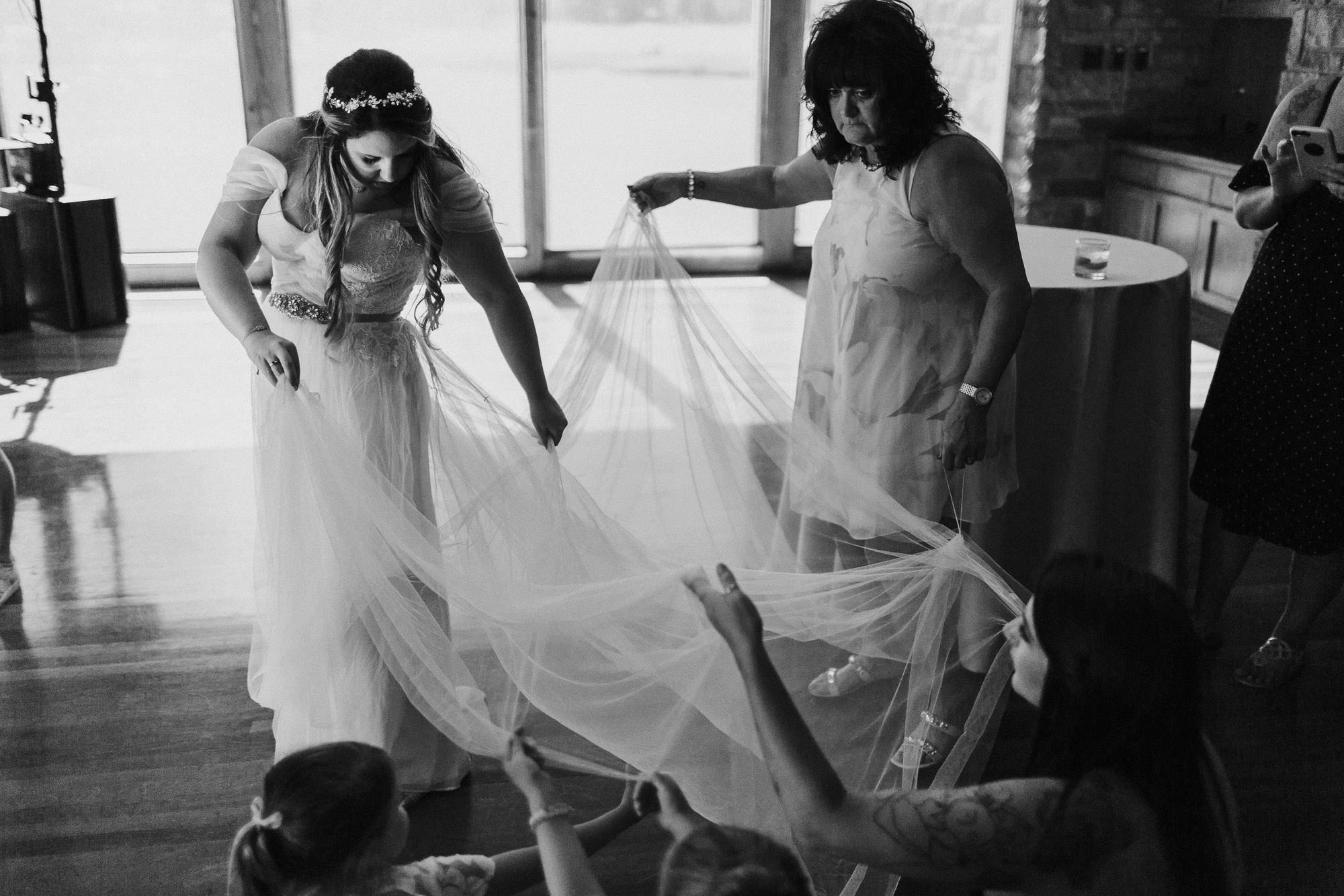 Friends help bride adjust dress at Broken Top Club in Bend, Oregon