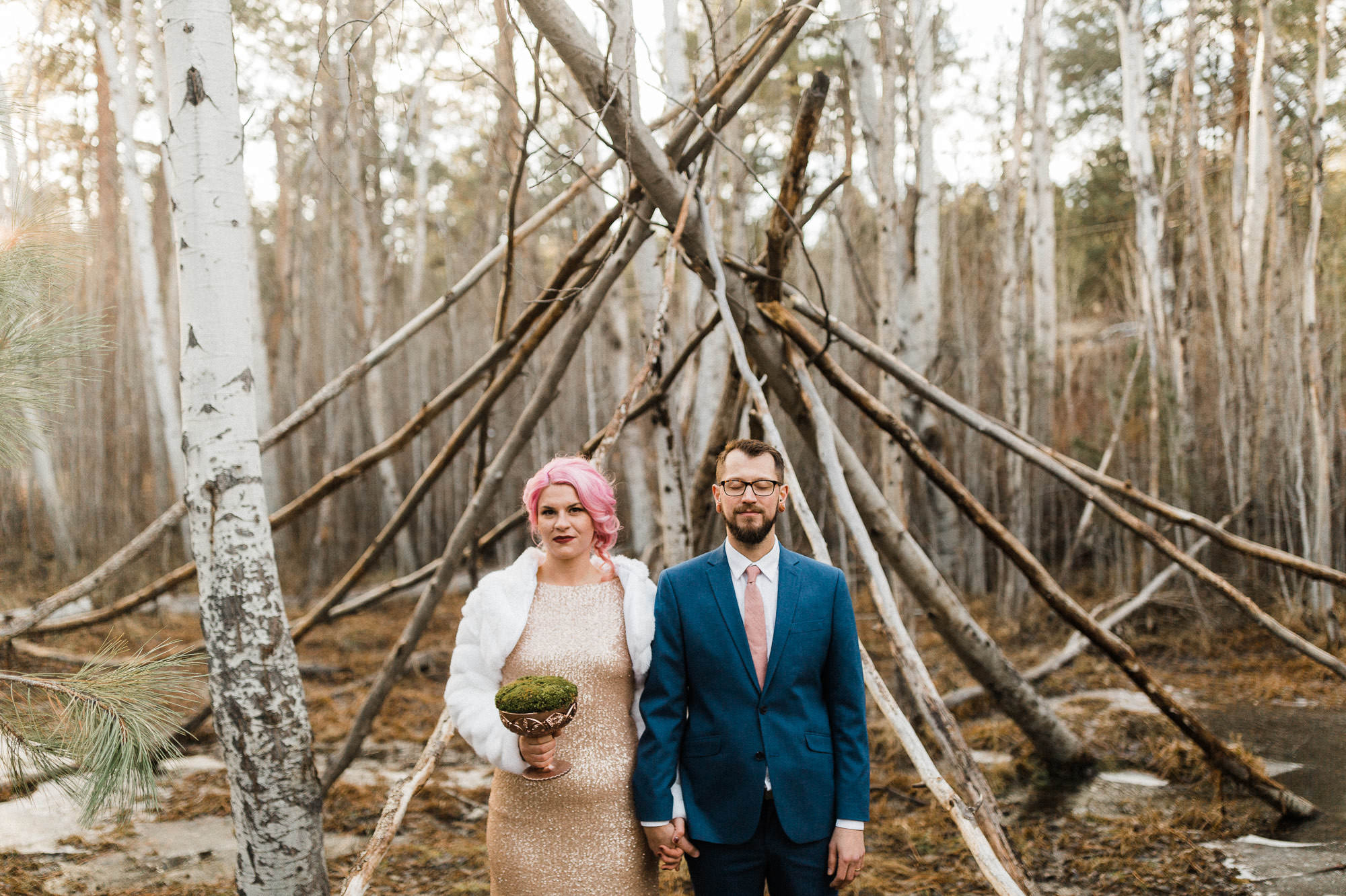 Bride and groom hold hands in front of a makeshift pole structure in Bend, Oregon