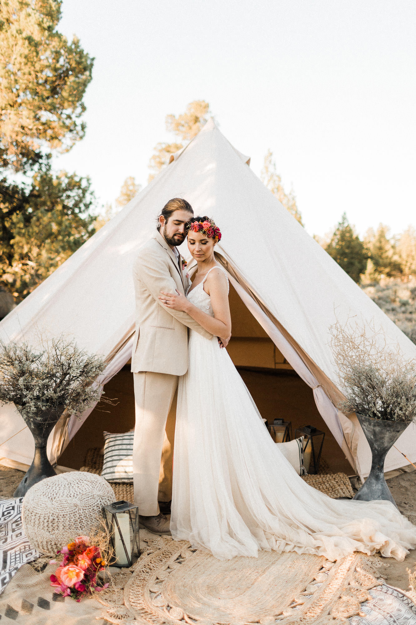 Bride and groom embrace in front of a bell tent in Bend, Oregon
