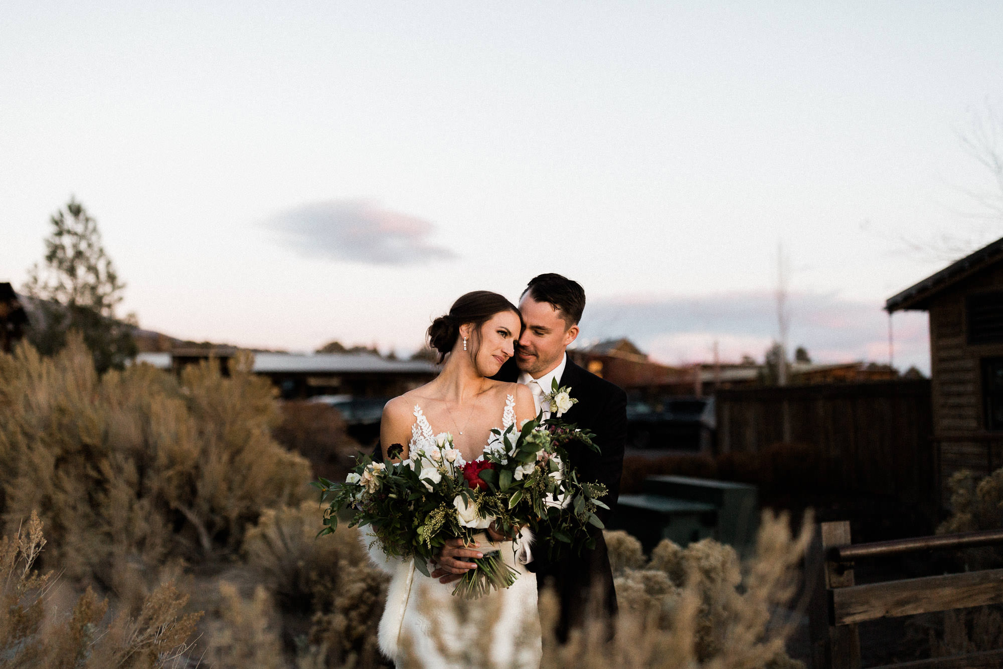 Bride and groom embrace at sunset at Brasada Ranch in Oregon