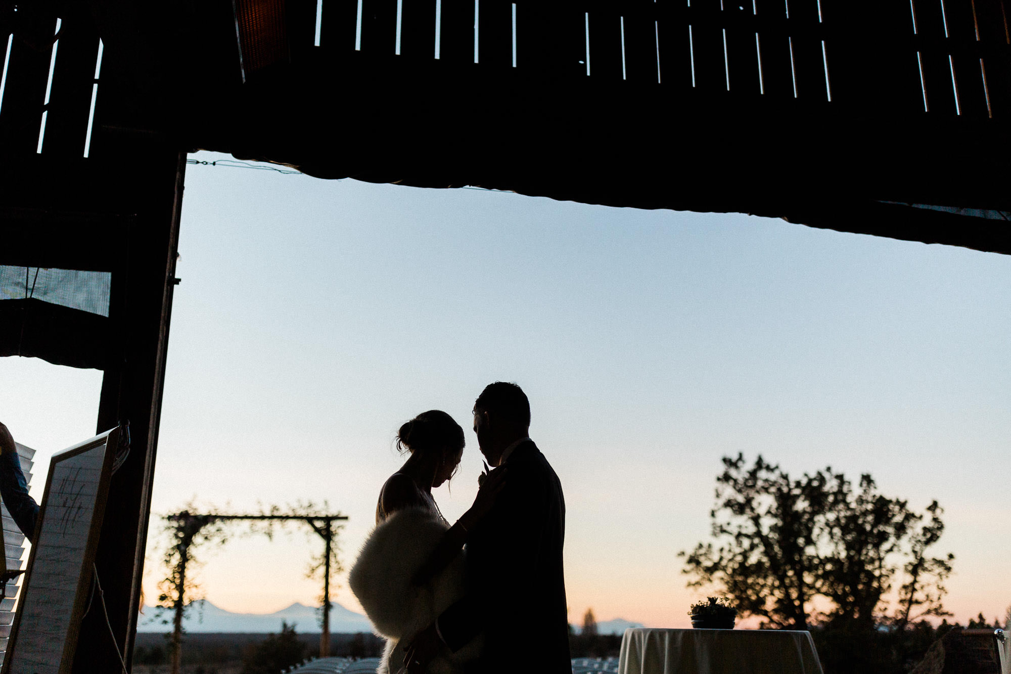Bride and groom are silhouetted at sunset at Brasada Ranch in Bend, Oregon