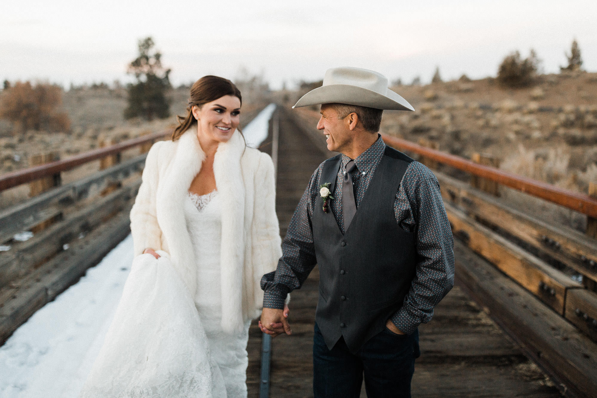 Bride and groom walk on foot bridge at Brasada Ranch in Bend, Oregon