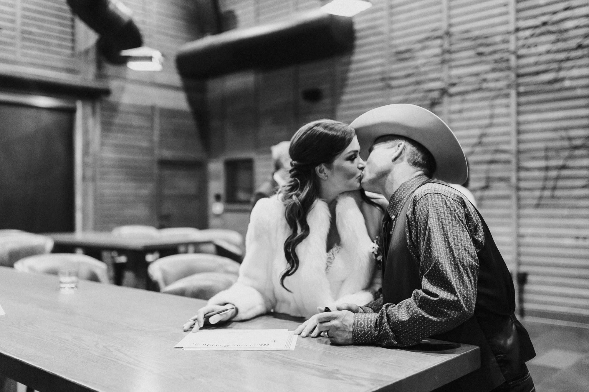 Bride and groom kiss while signing marriage license at Brasada Ranch in Bend, Oregon