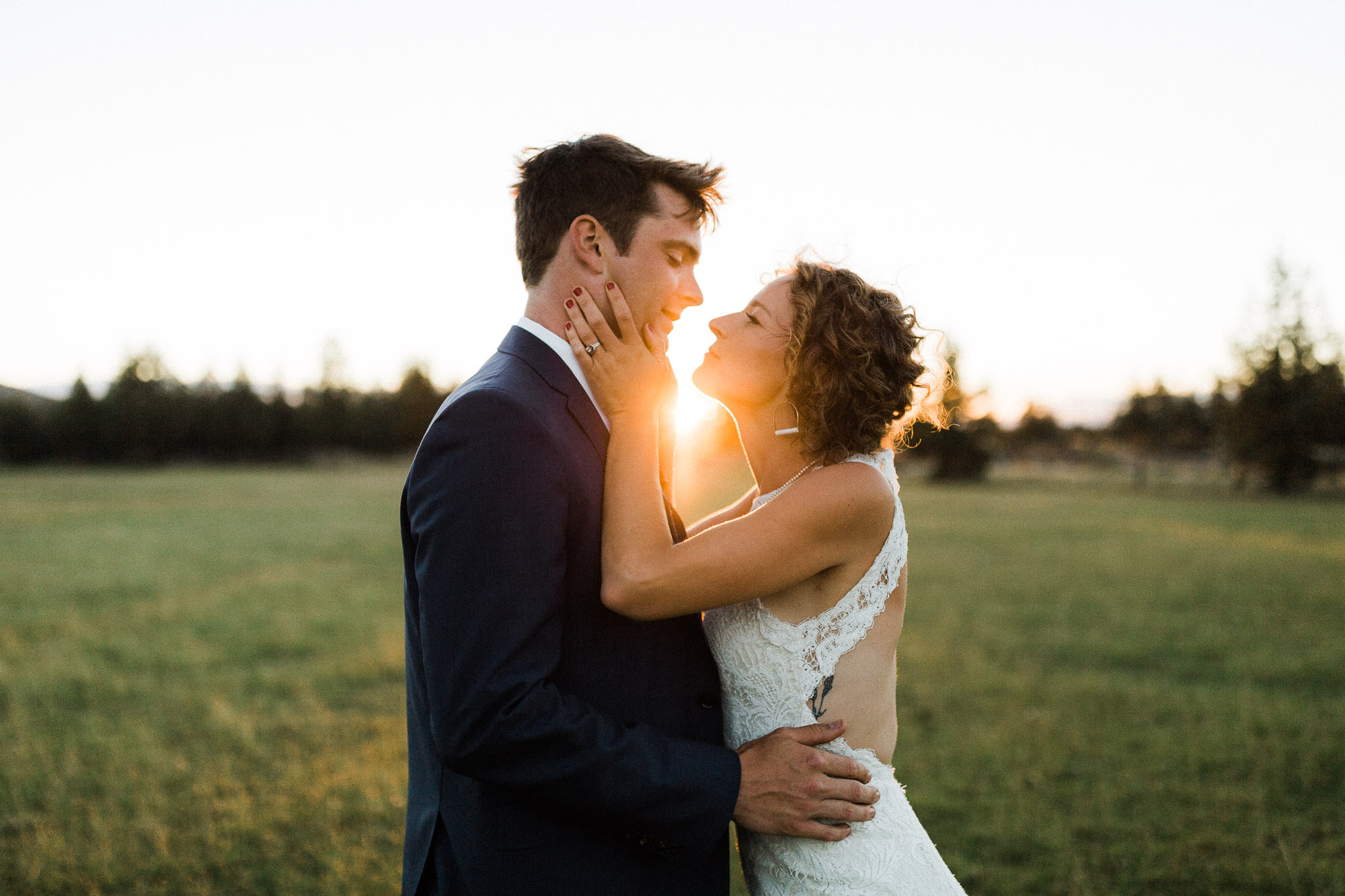 Bride holds grooms face in her hands at sunset in Redmond, Oregon