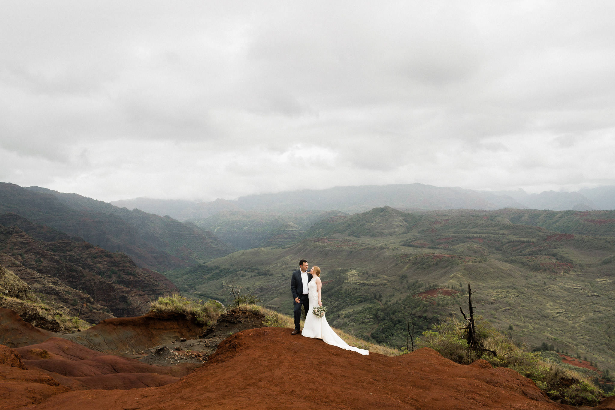 Bride and groom embrace at Waimea Canyon on Kauai, Hawaii