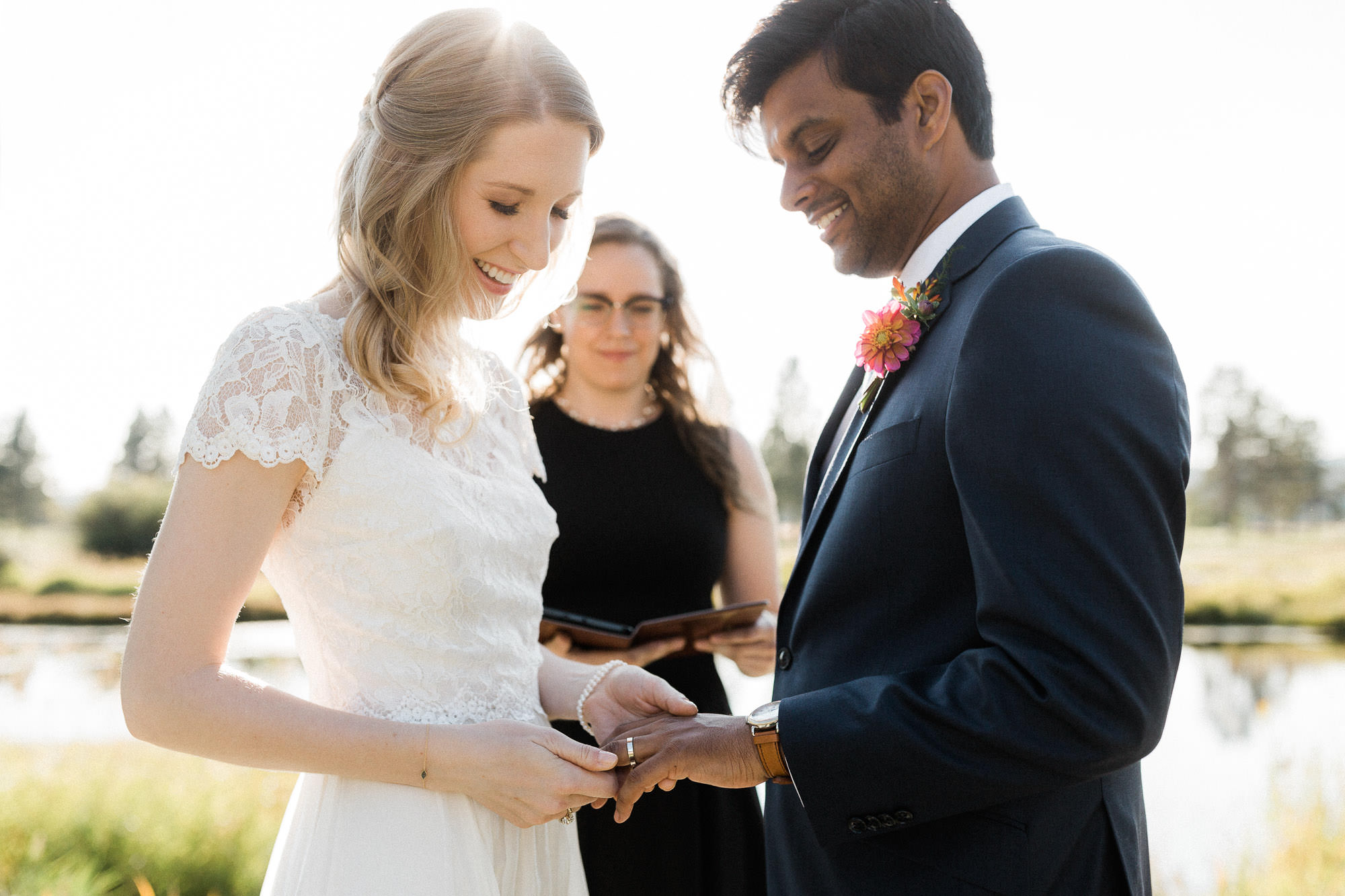 Bride places ring on groom's finger at Sunriver Resort in Oregon