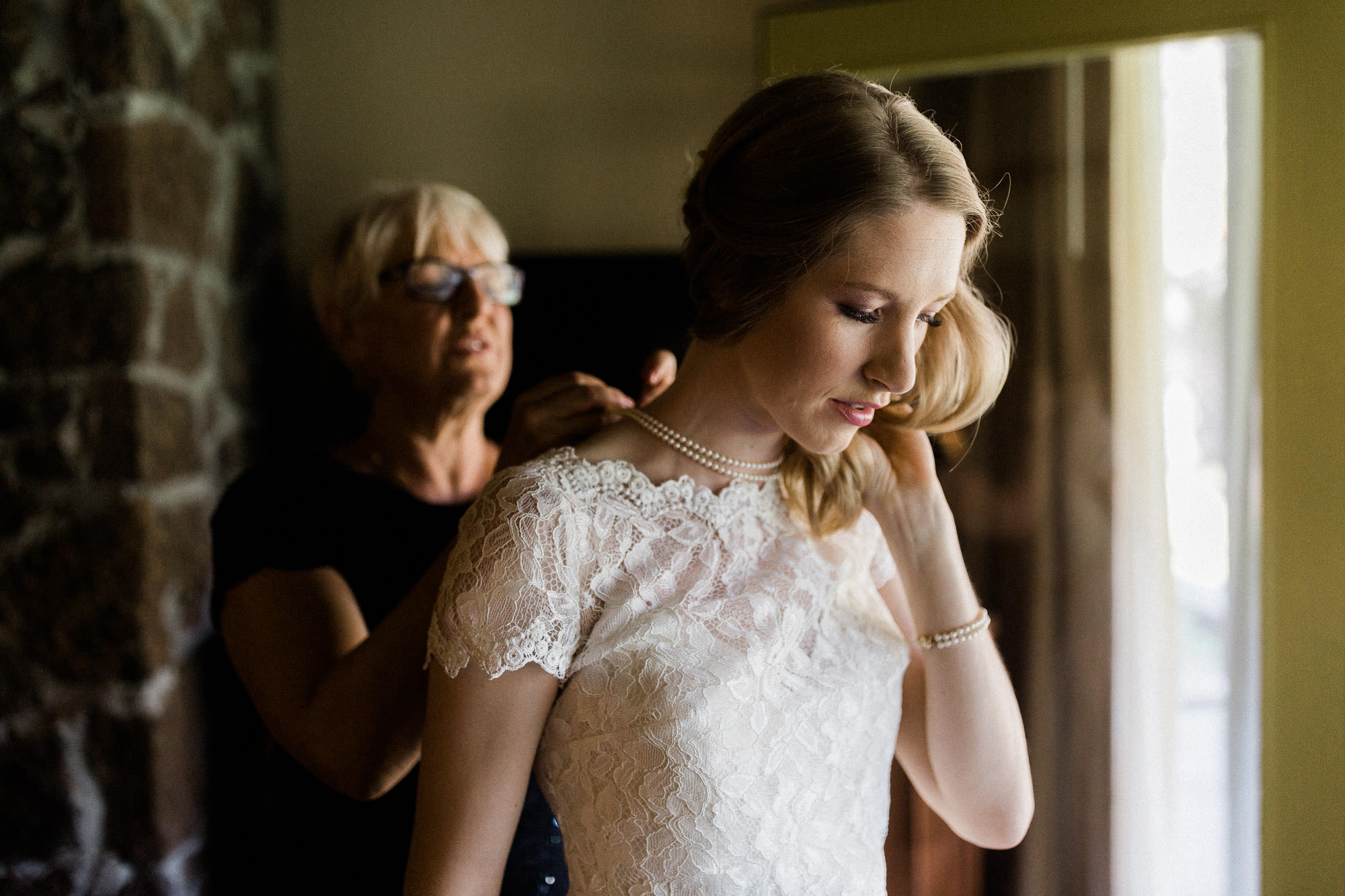 A mother clasps a necklace on a bride at Sunriver Resort in Oregon