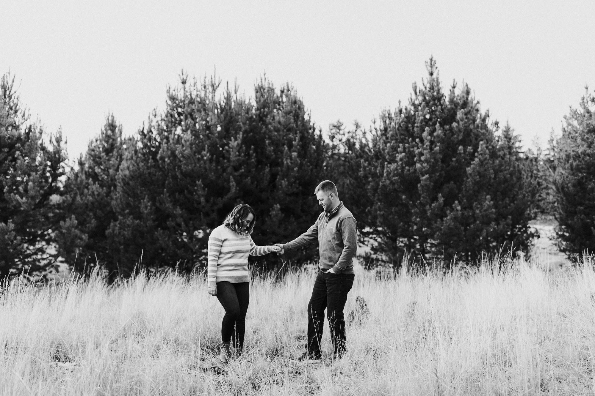 A couple holds hands in a field in Bend, Oregon