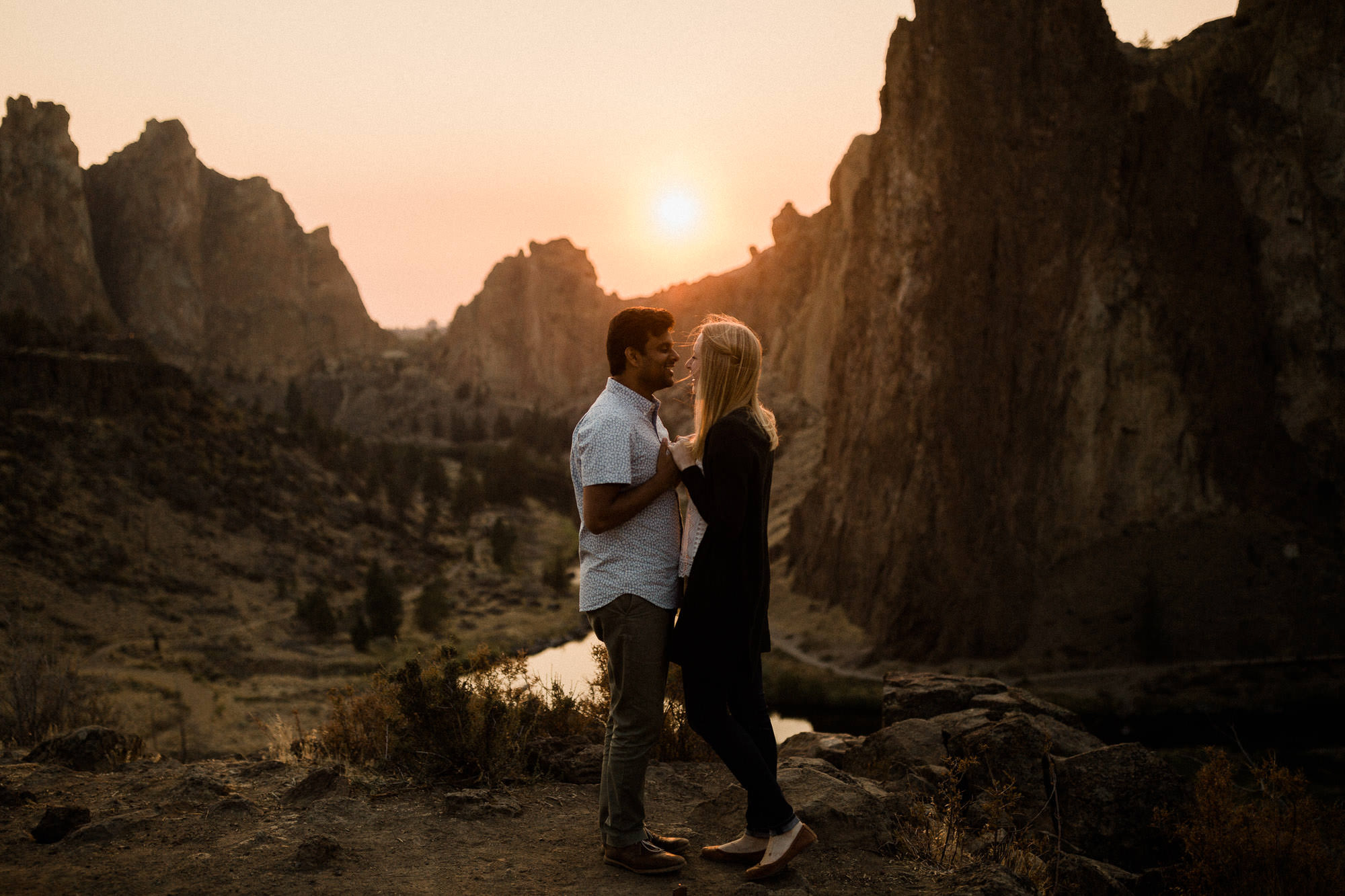 Couple hold hands at sunset at Smith Rock State Park in Oregon