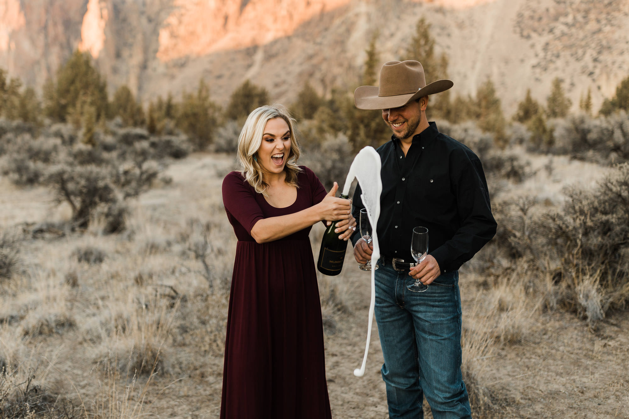 A couple pops a bottle of champagne at Smith Rock State Park in Oregon
