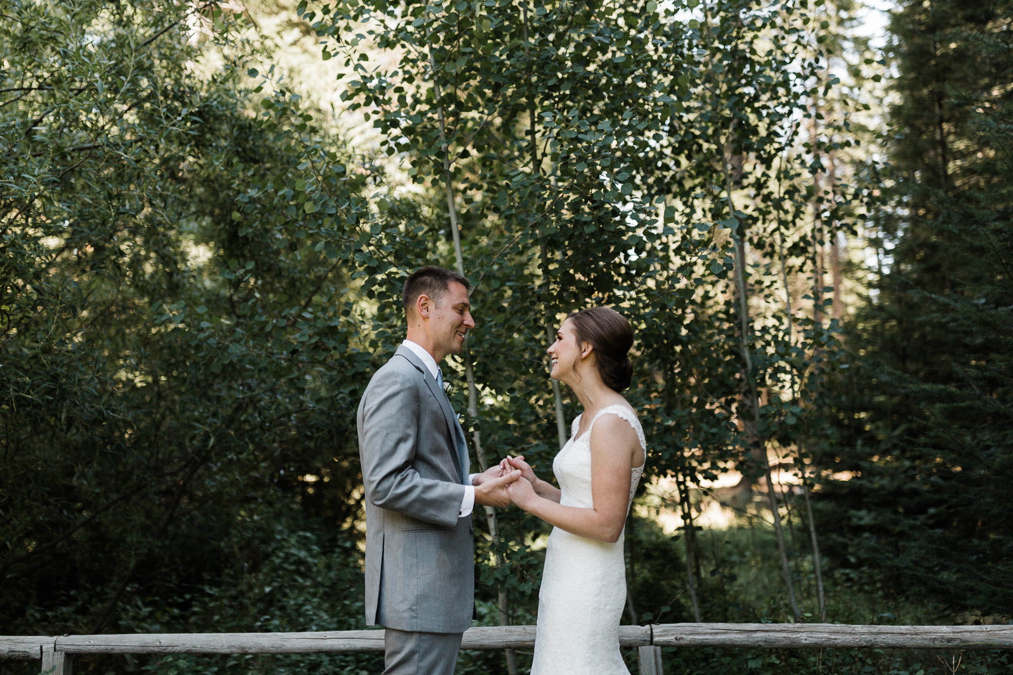 Bride and groom hold hands while looking at each other at Black Butte Ranch