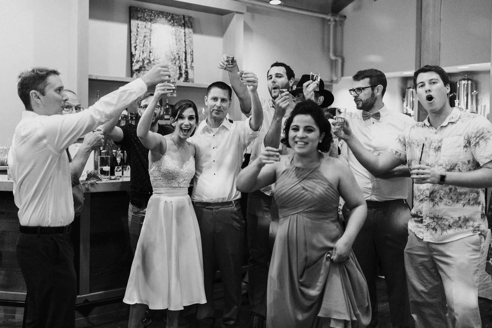 Bride, groom, and guests lift glasses in a "cheers" at Black Butte Ranch