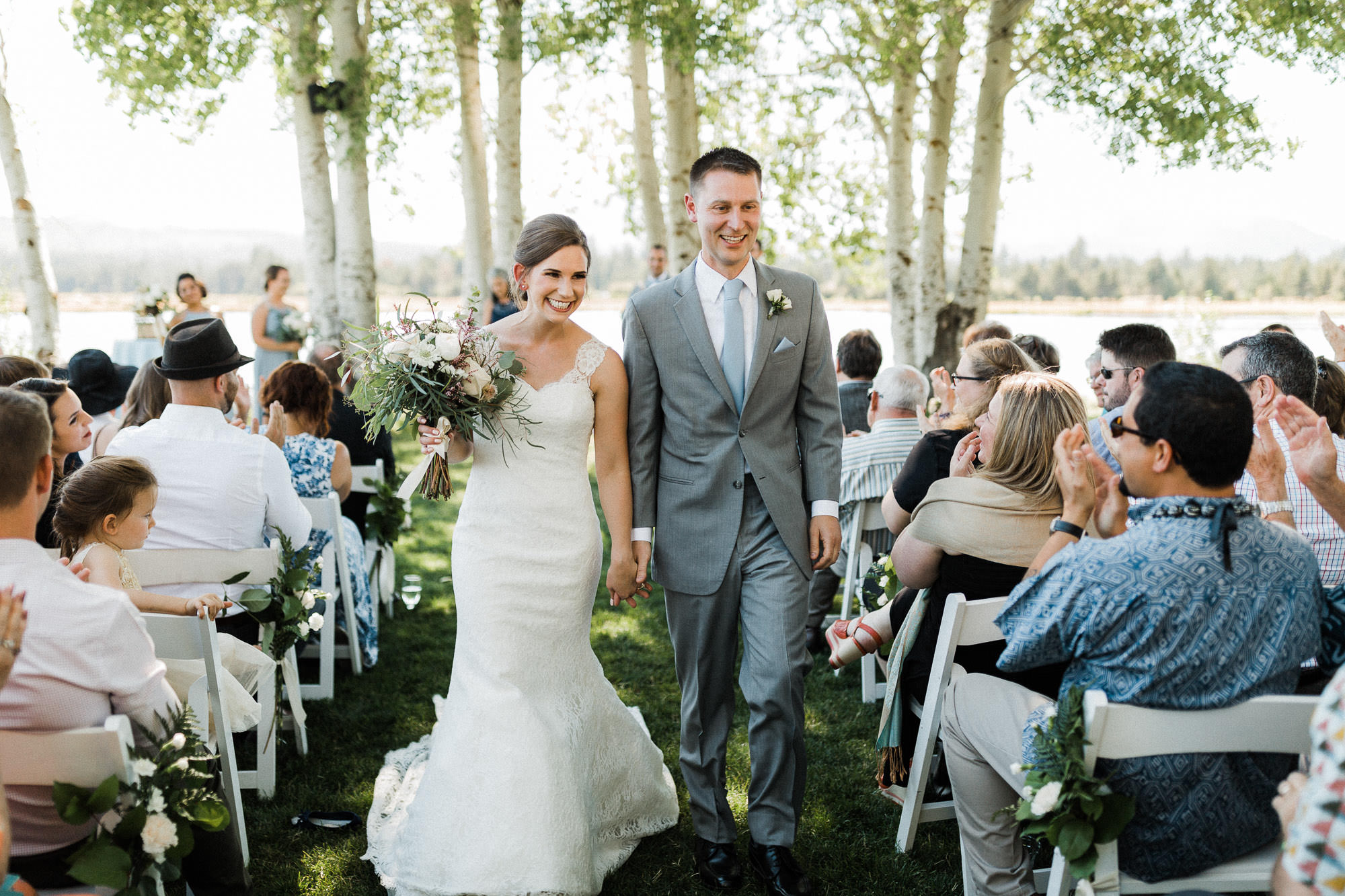 Bride and groom smile as they walk down the aisle after getting married at Black Butte Ranch