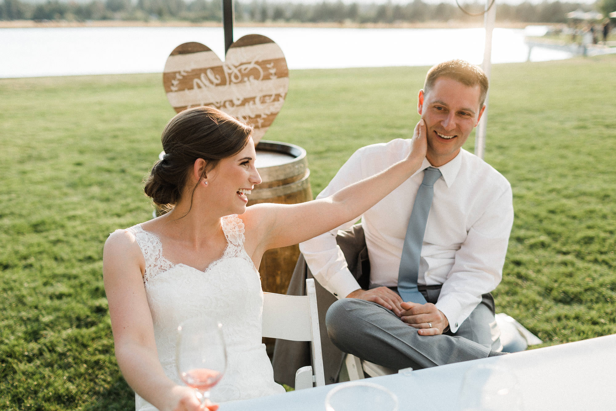 Bride touches groom's cheek as the laugh and listen to toasts at Black Butte Ranch