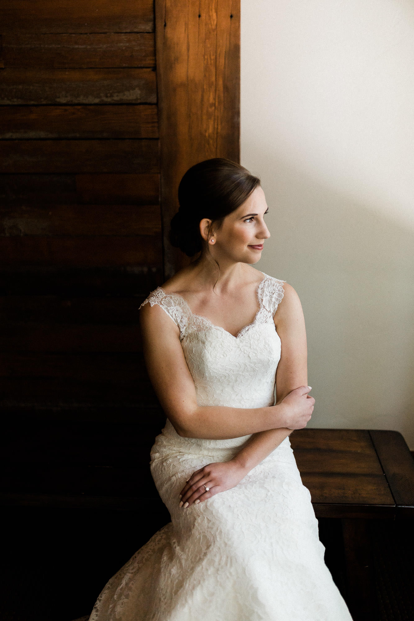 Bride poses for a portrait in front of a window at Black Butte Ranch