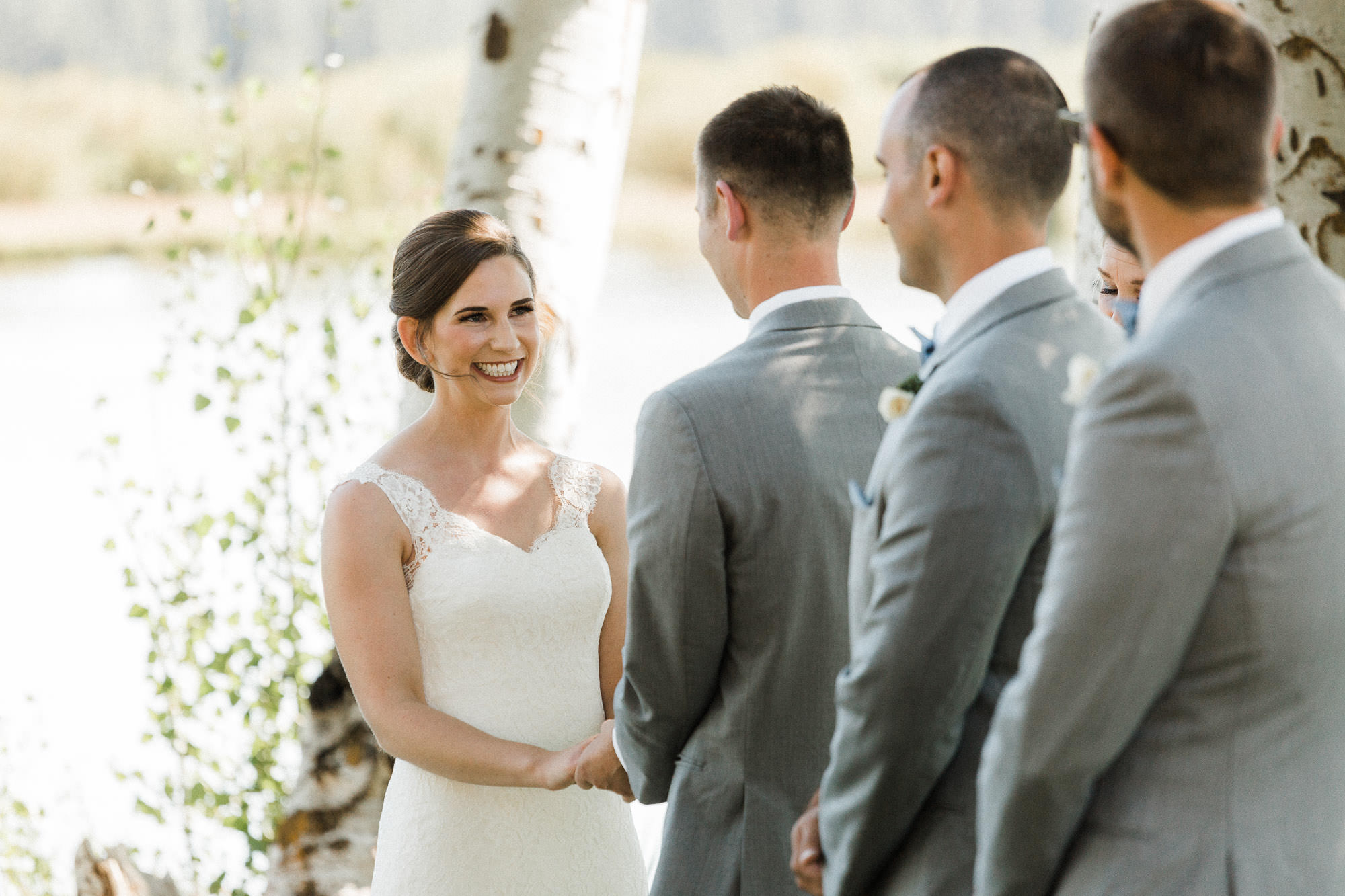Bride smiles and looks at groom during wedding ceremony at Black Butte Ranch