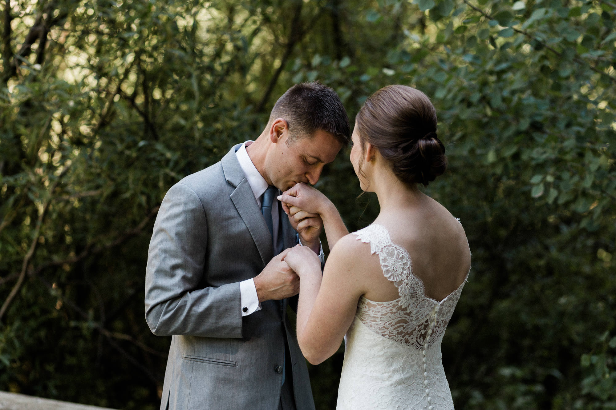 Groom kisses the hand of his bride at Black Butte Ranch in Oregon