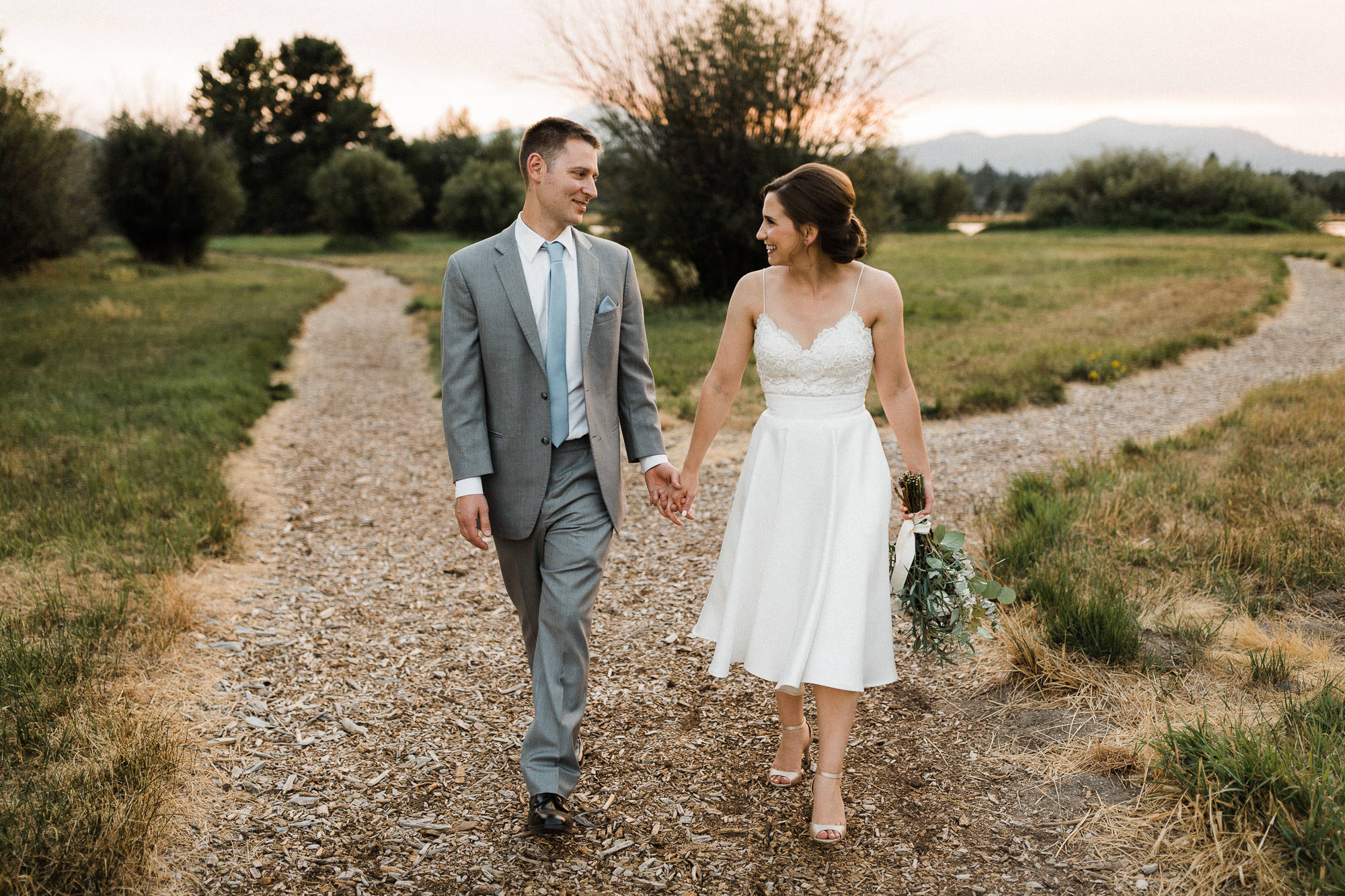 Bride and groom walk on a trail during sunset at Black Butte Ranch 