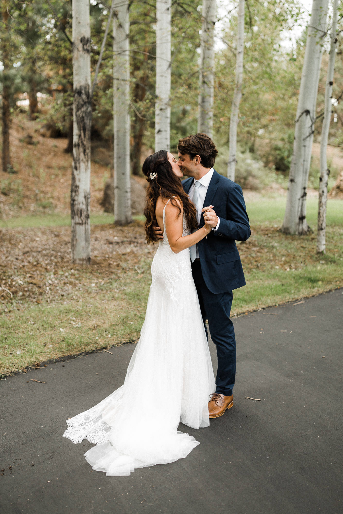 Bride and groom kiss in front of aspen trees at Broken Top Club in Bend, Oregon