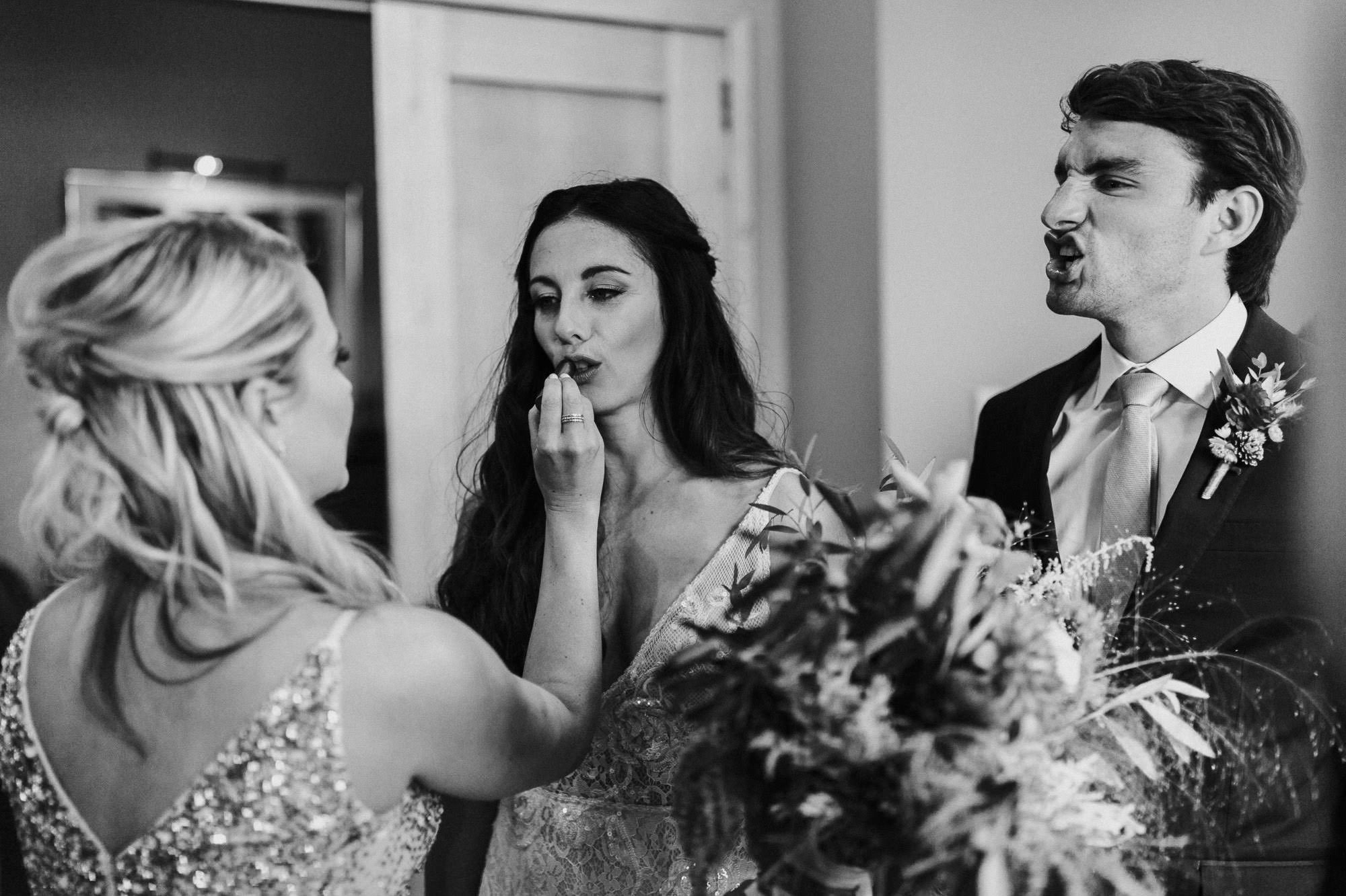 Groom imitates bride as bridesmaid touches up her lipstick in Bend, Oregon