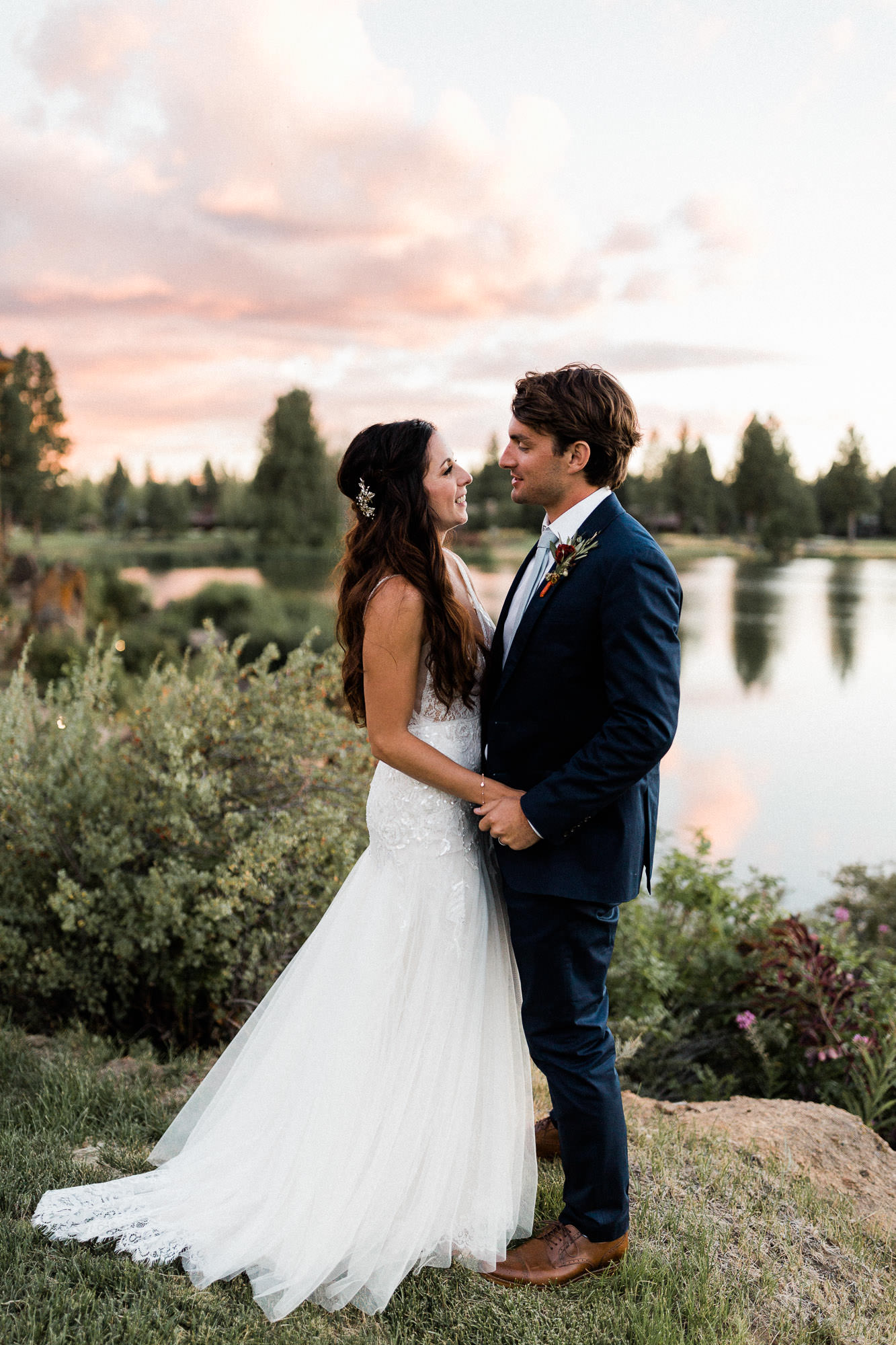 Bride and groom hold hands at sunset at Broken Top Club in Bend, Oregon