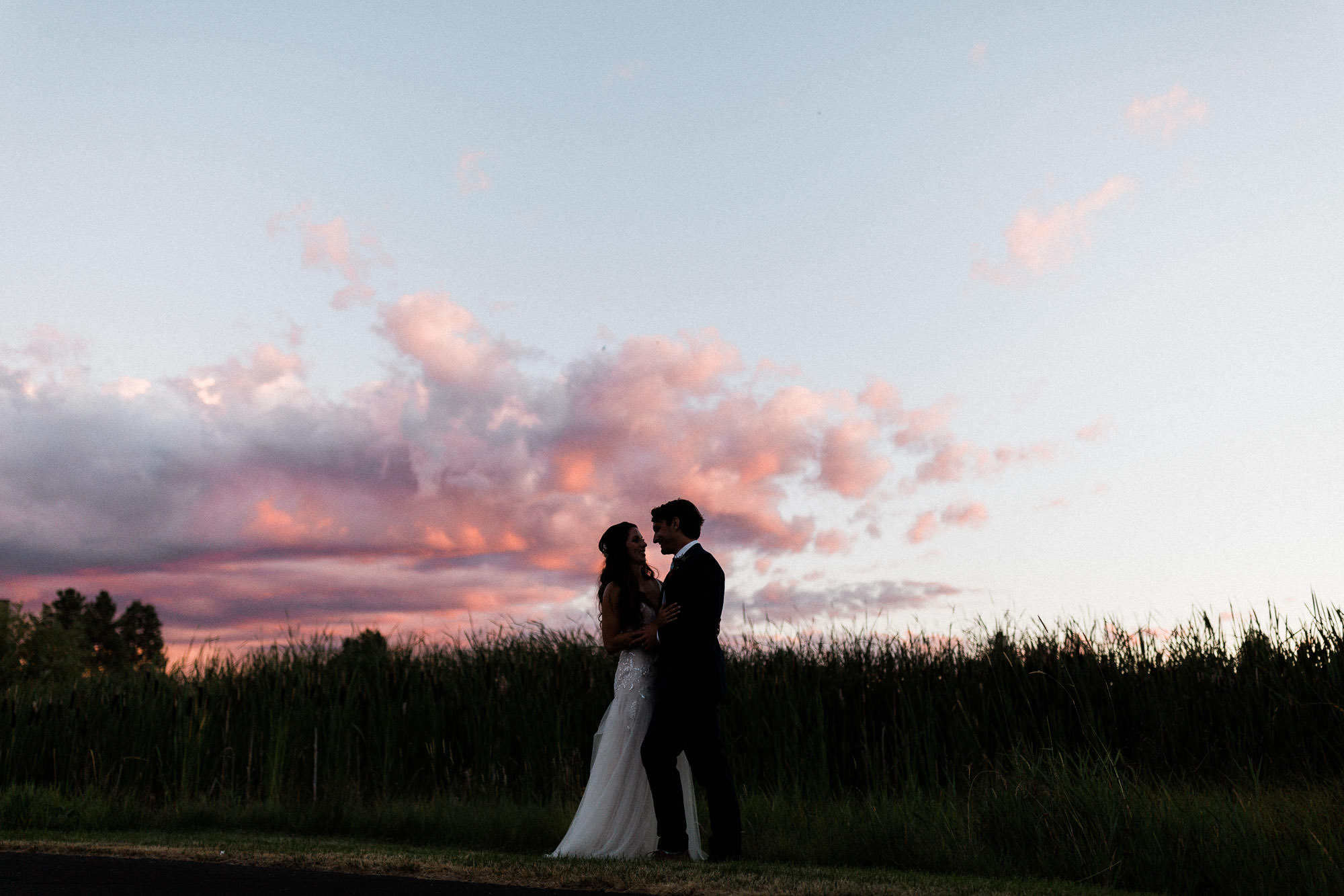 Bride and groom silhouetted against pink sunset at Broken Top Club in Bend, Oregon