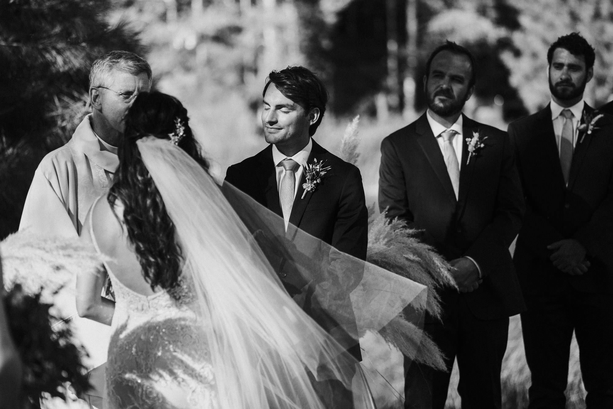 Sunlight hits groom's face during ceremony at Broken Top Club in Bend, Oregon