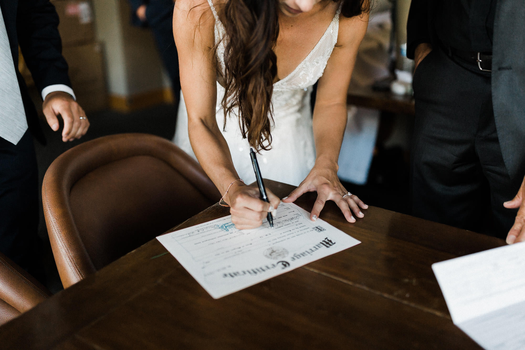 Bride signs marriage license at Broken Top Club in Bend, Oregon