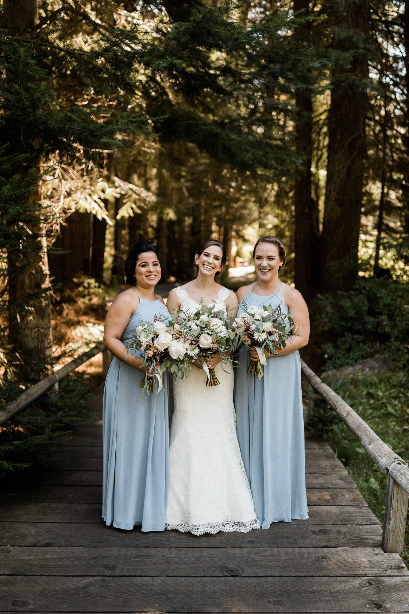 Bride and bridesmaids pose on a boardwalk at Black Butte Ranch
