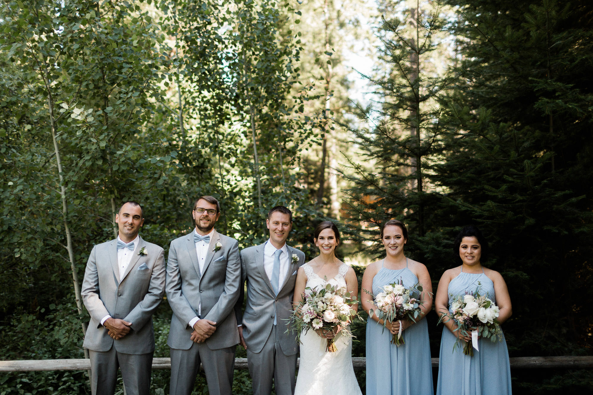 The wedding party poses in front of trees at Black Butte Ranch in Oregon