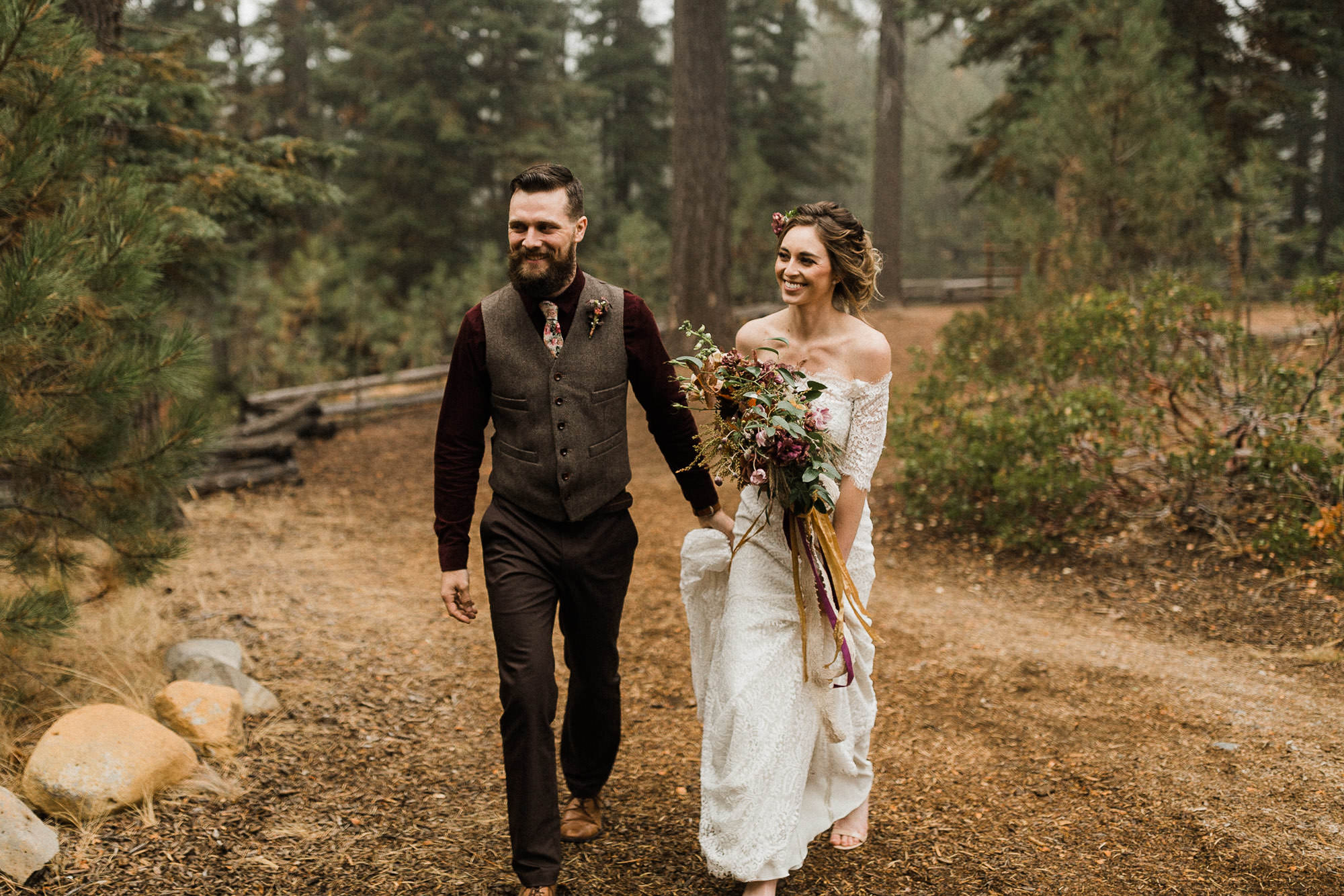 Bride and groom walk through the forest at Skyliner Lodge in Bend, Oregon