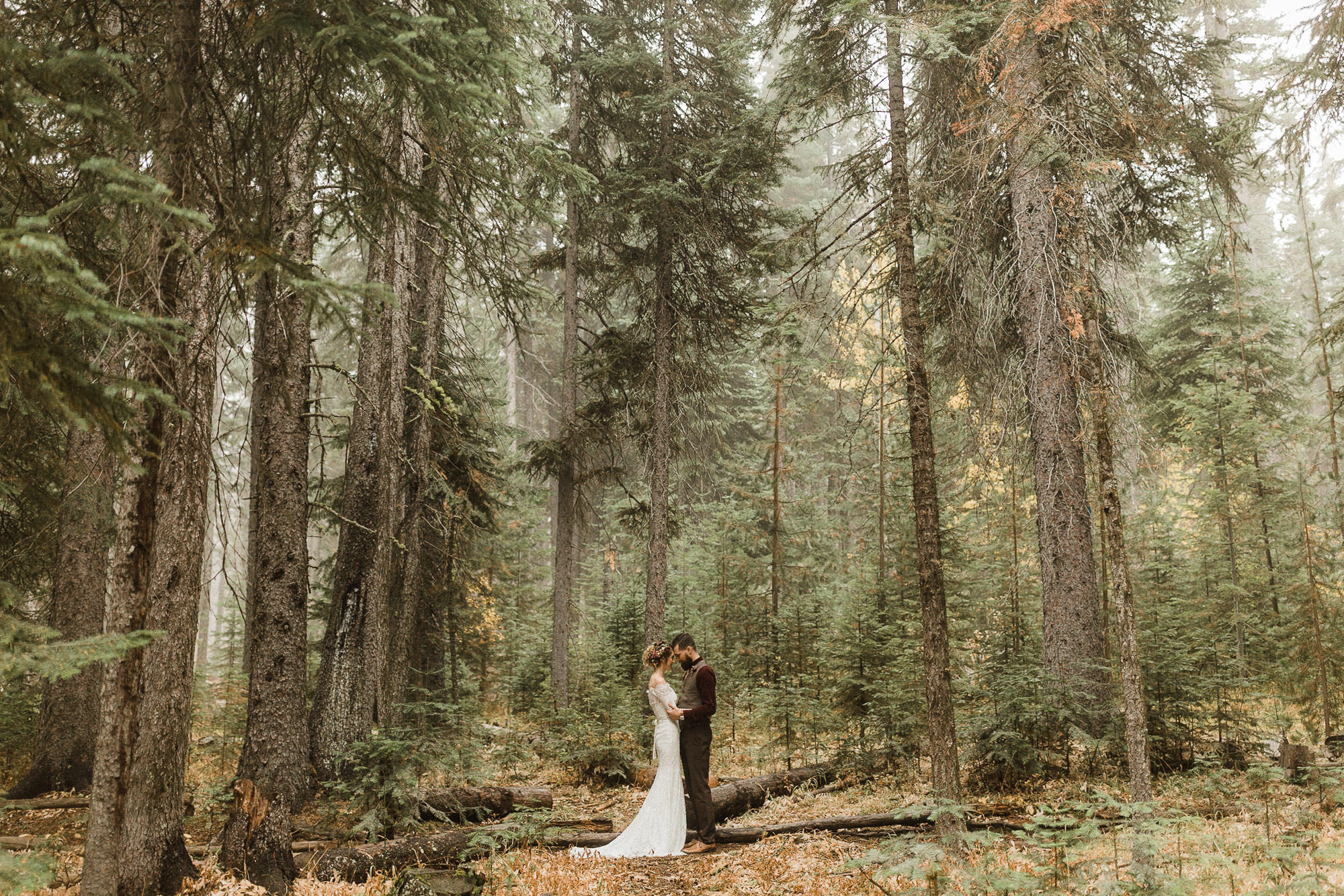 Bride and groom pose in the forest at a venue in Bend, Oregon