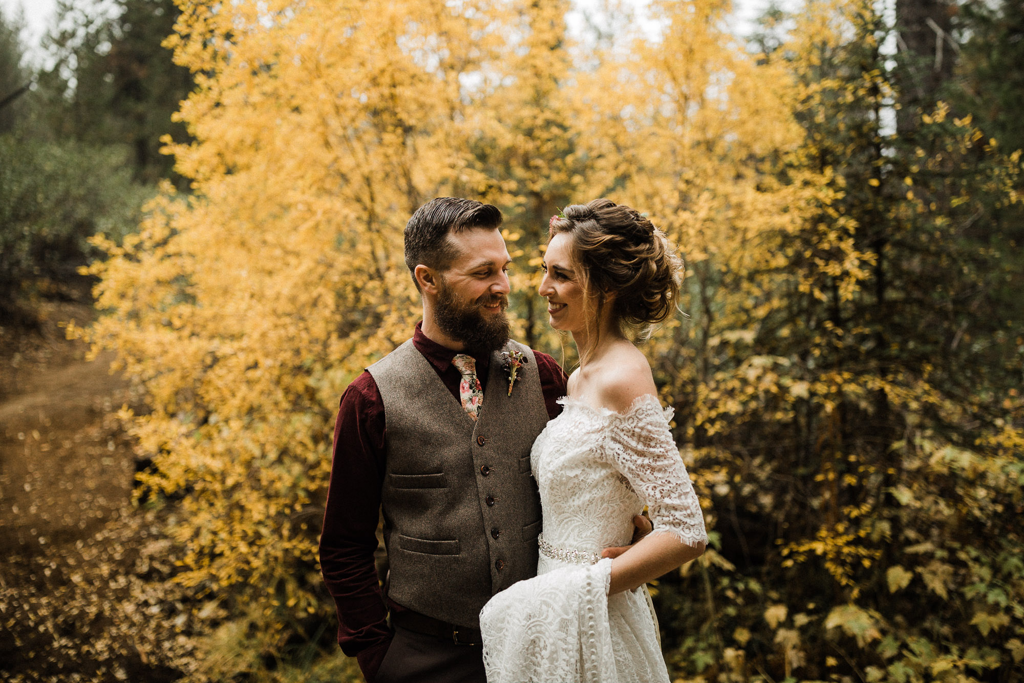 Bride and groom pose in front of fall foliage in Bend, Oregon