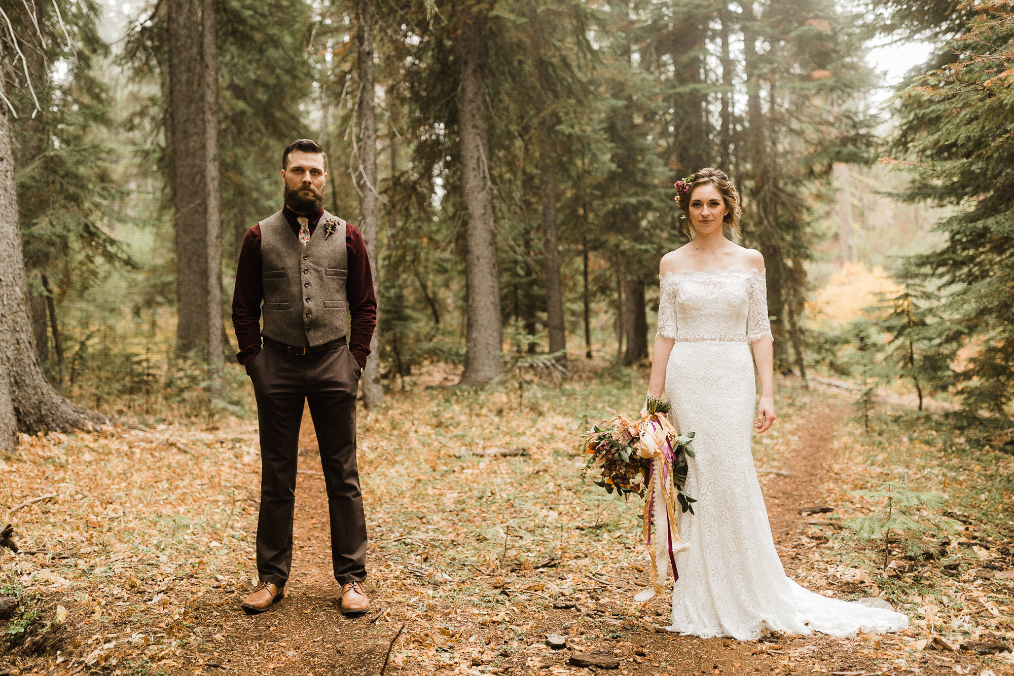 Bride and groom pose on a trail in the forest in Bend, Oregon