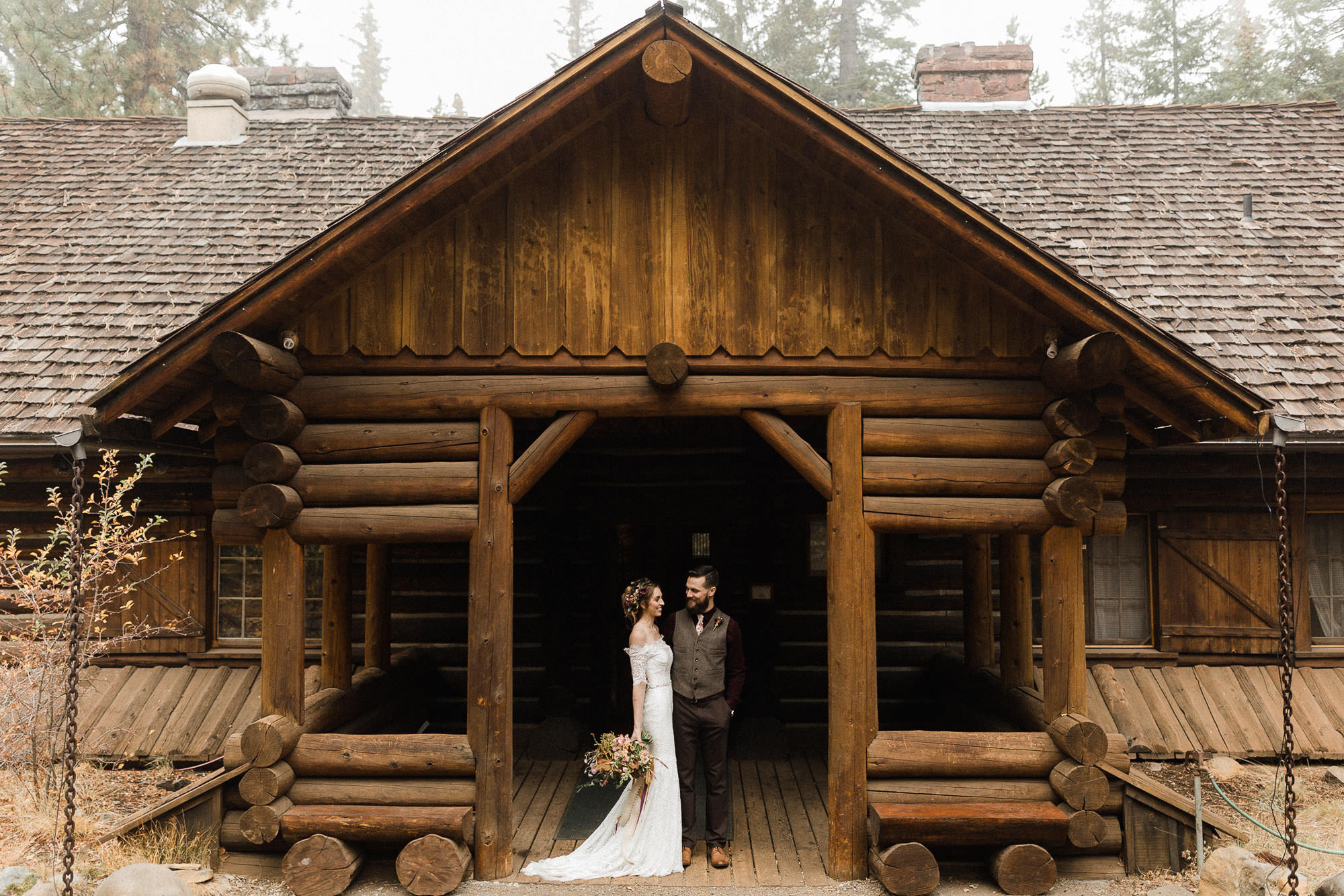 Bride and groom pose in front of Skyliner Lodge in Bend, Oregon