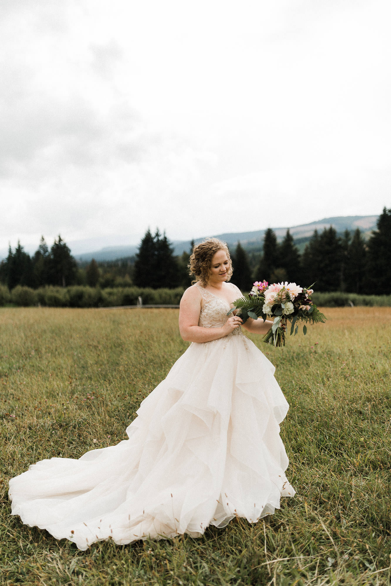 The bride looks at her bouquet at Mt. View Orchards in Mt Hood Oregon.