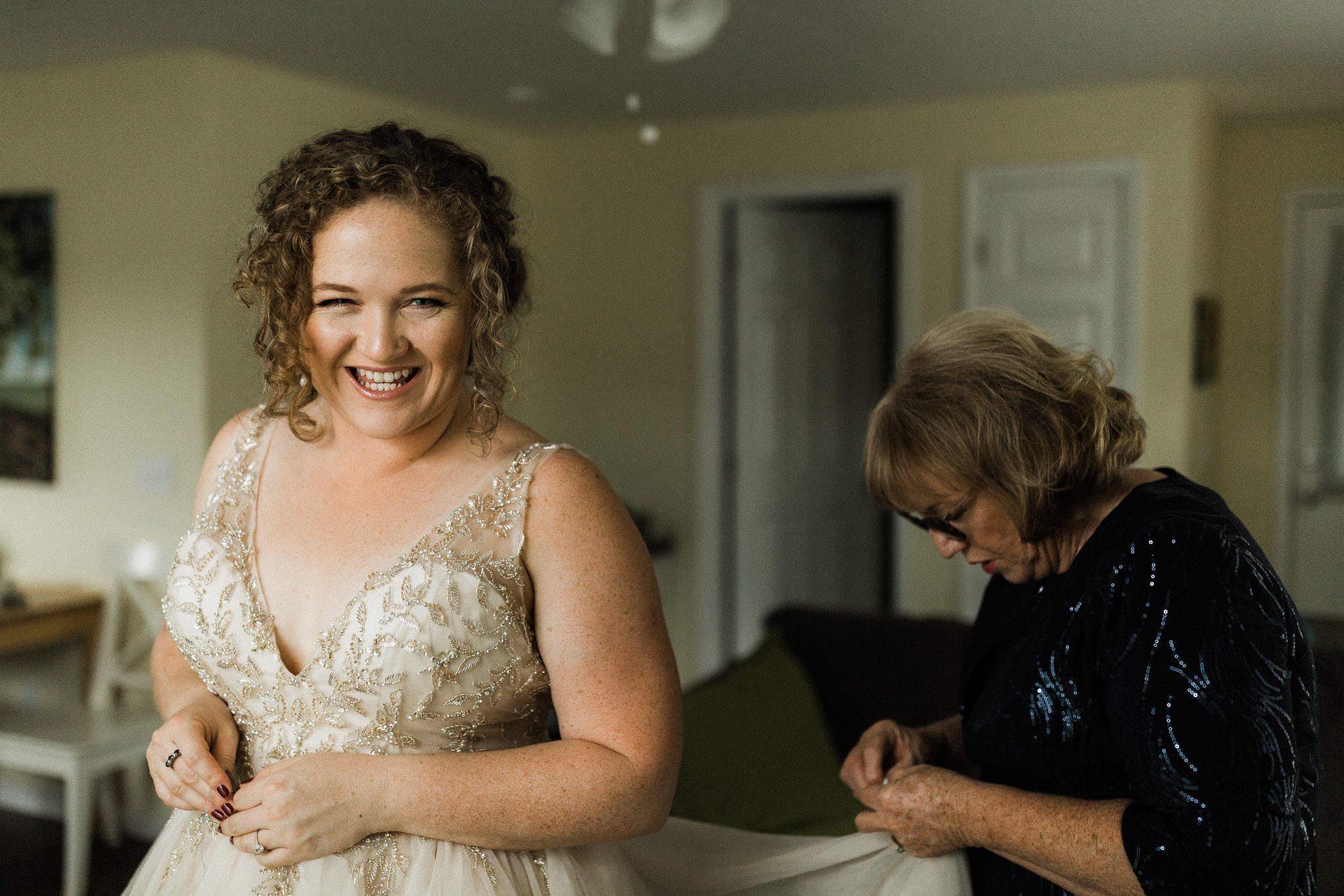 Bride laughs as her mother makes adjustments to her dress near Hood River, Oregon.