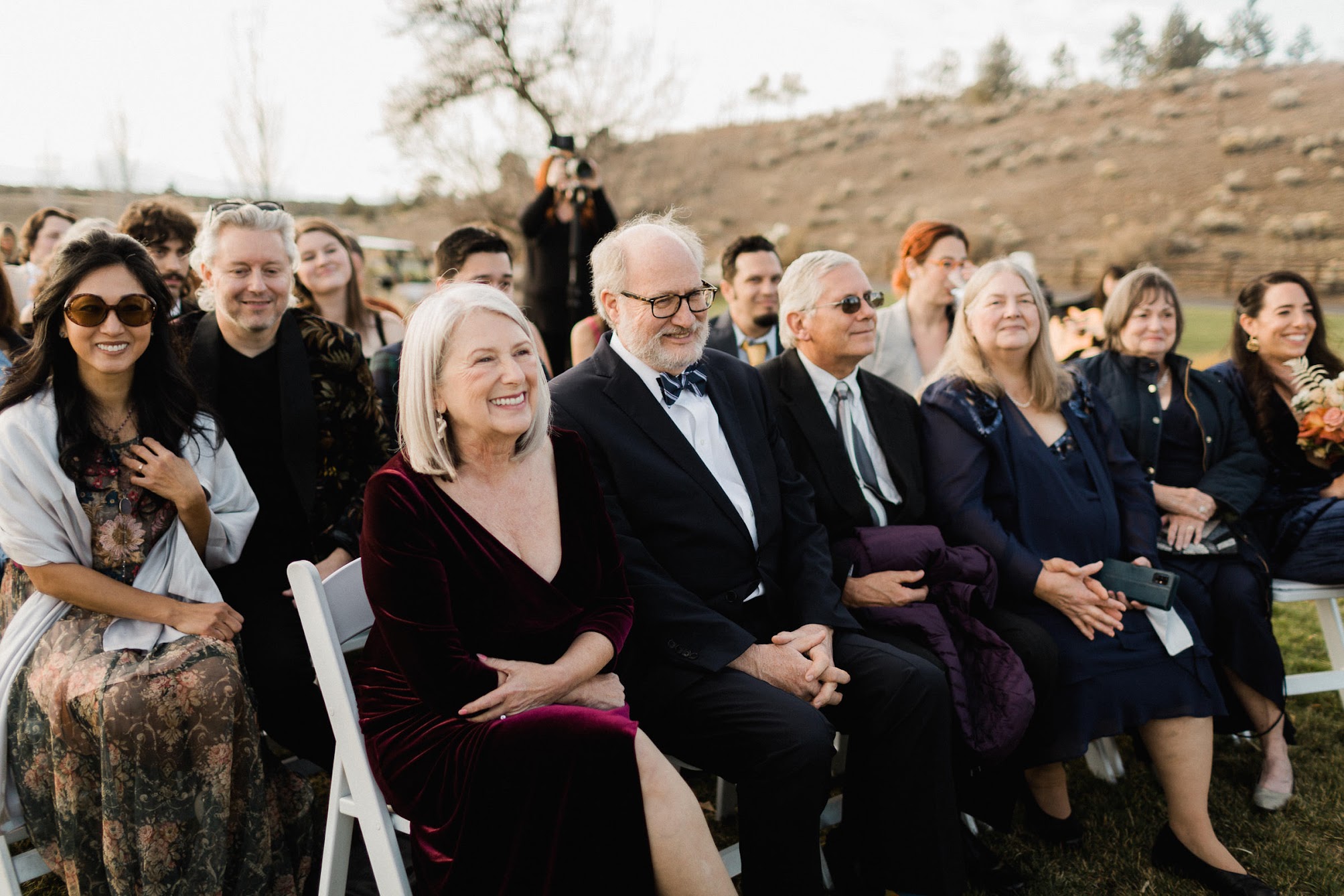 Guests smiling while sitting down watching the cermeony 