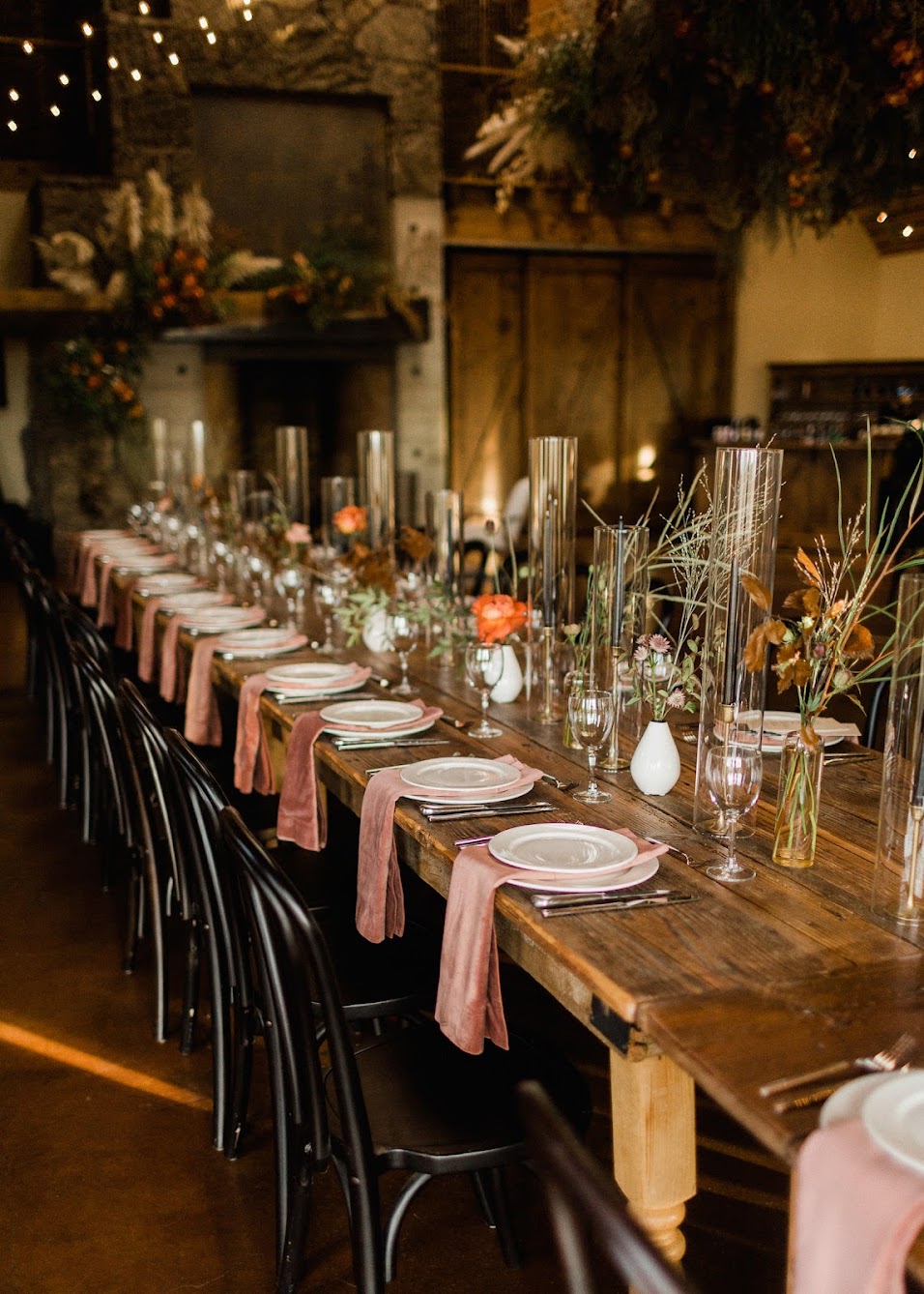 Black bentwood chairs and farm tables for guests to sit at for the wedding reception.