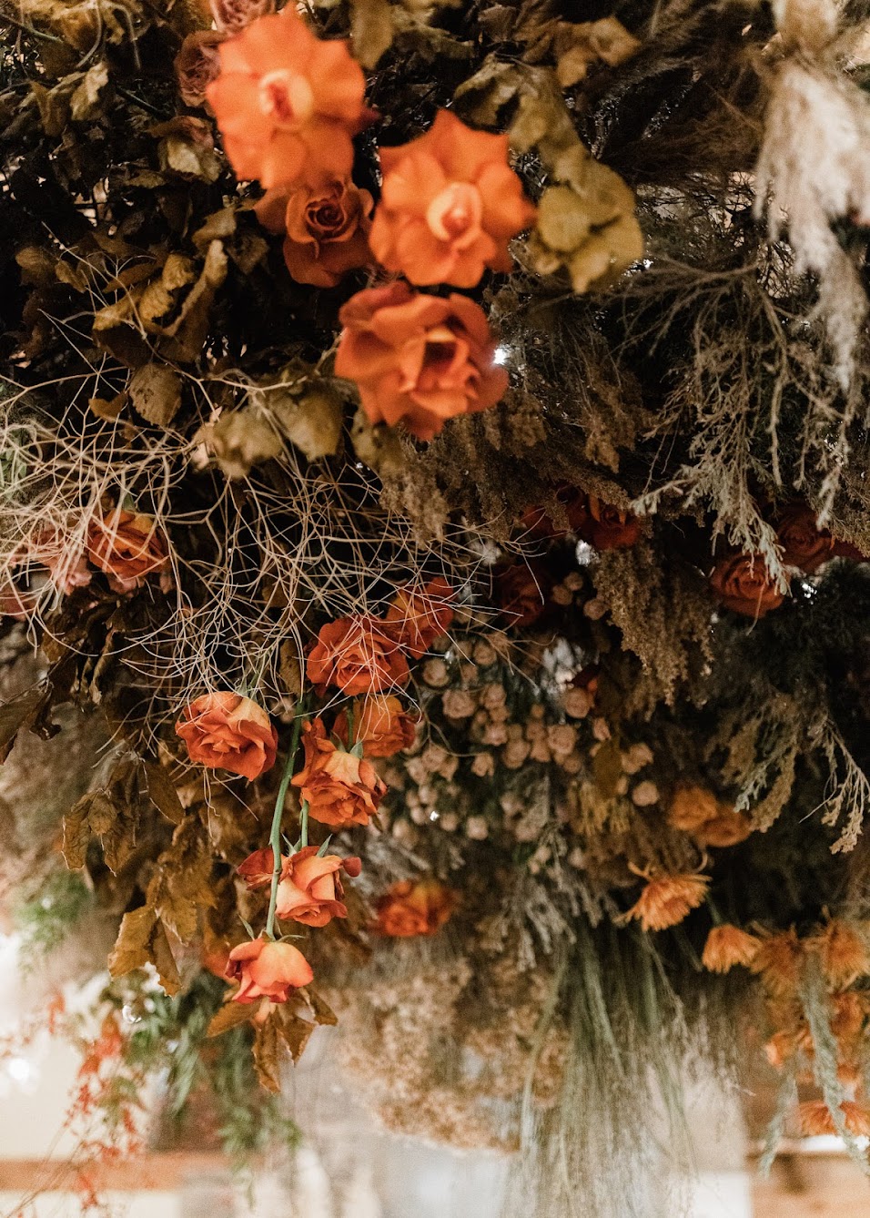 large floral installation with fresh and dried ferns, colorful florals, and fresh greenery hanging from the ceiling. 