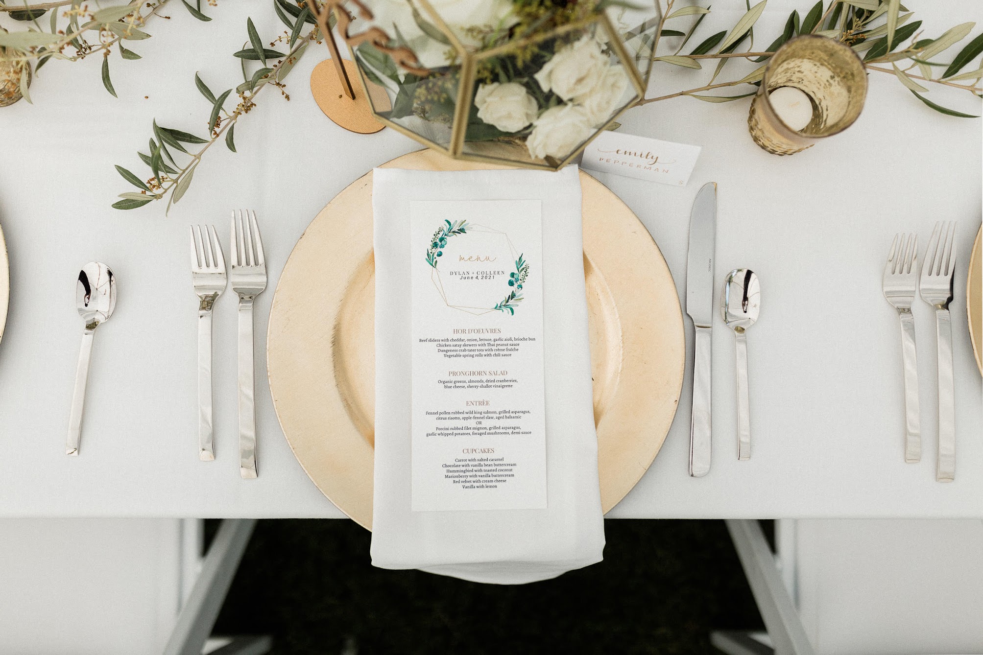 birds-eye view of the table, gold charger, white napkins with a square hold and a menu on top of it