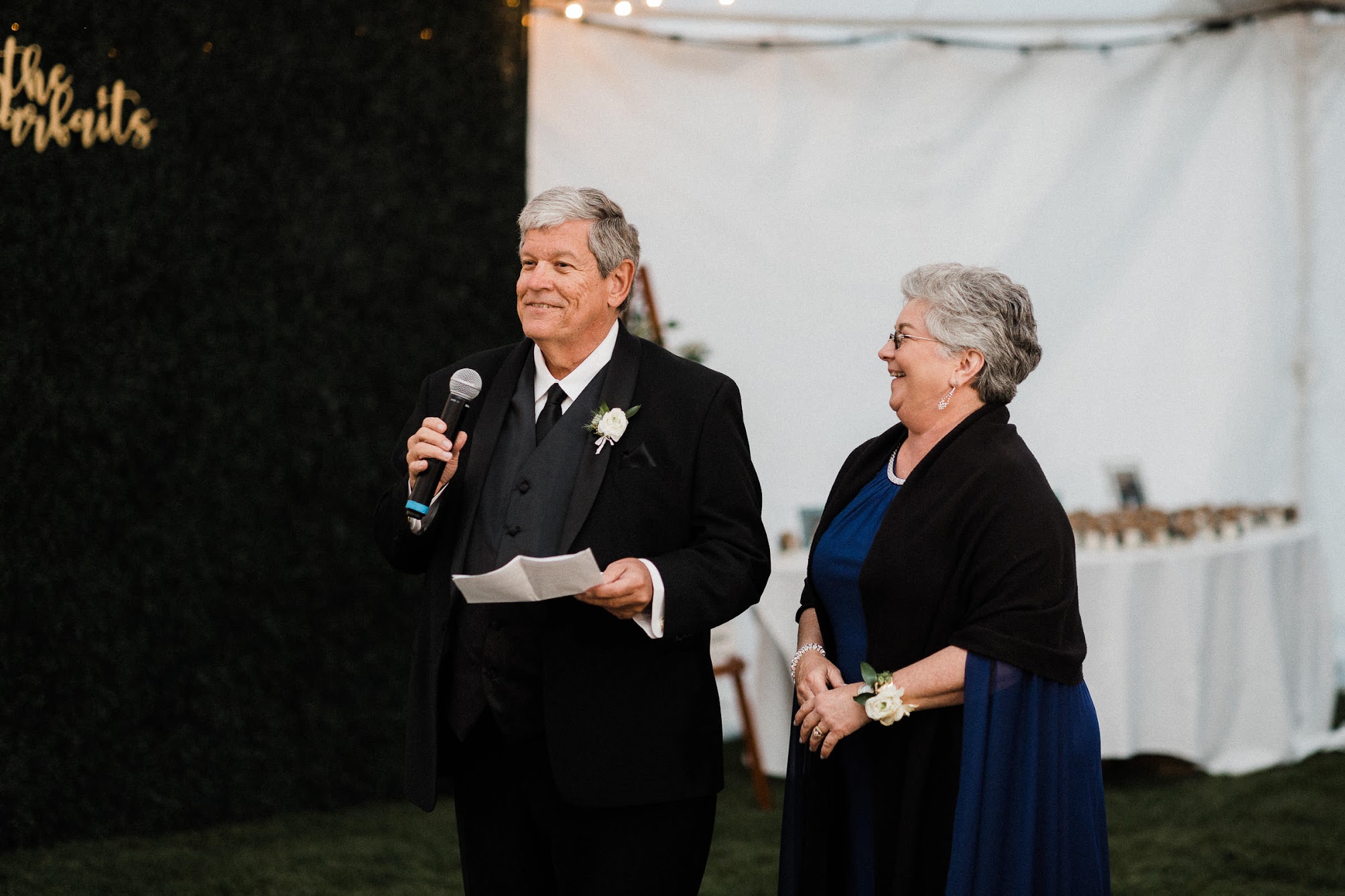 mom and dad holding a microphone giving a speech 