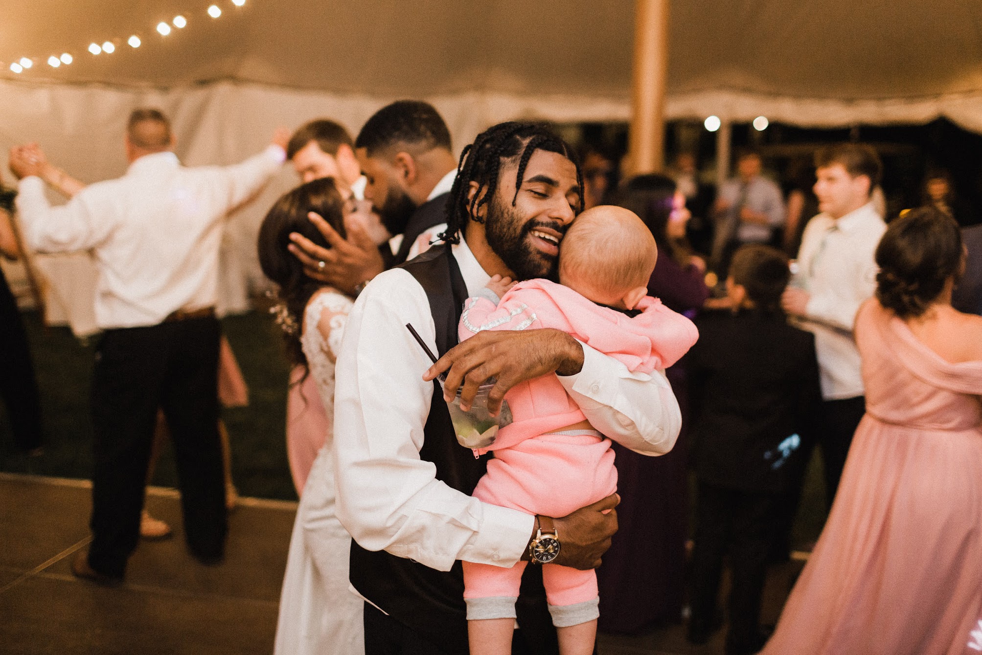 A groomsmen dancing with his baby 