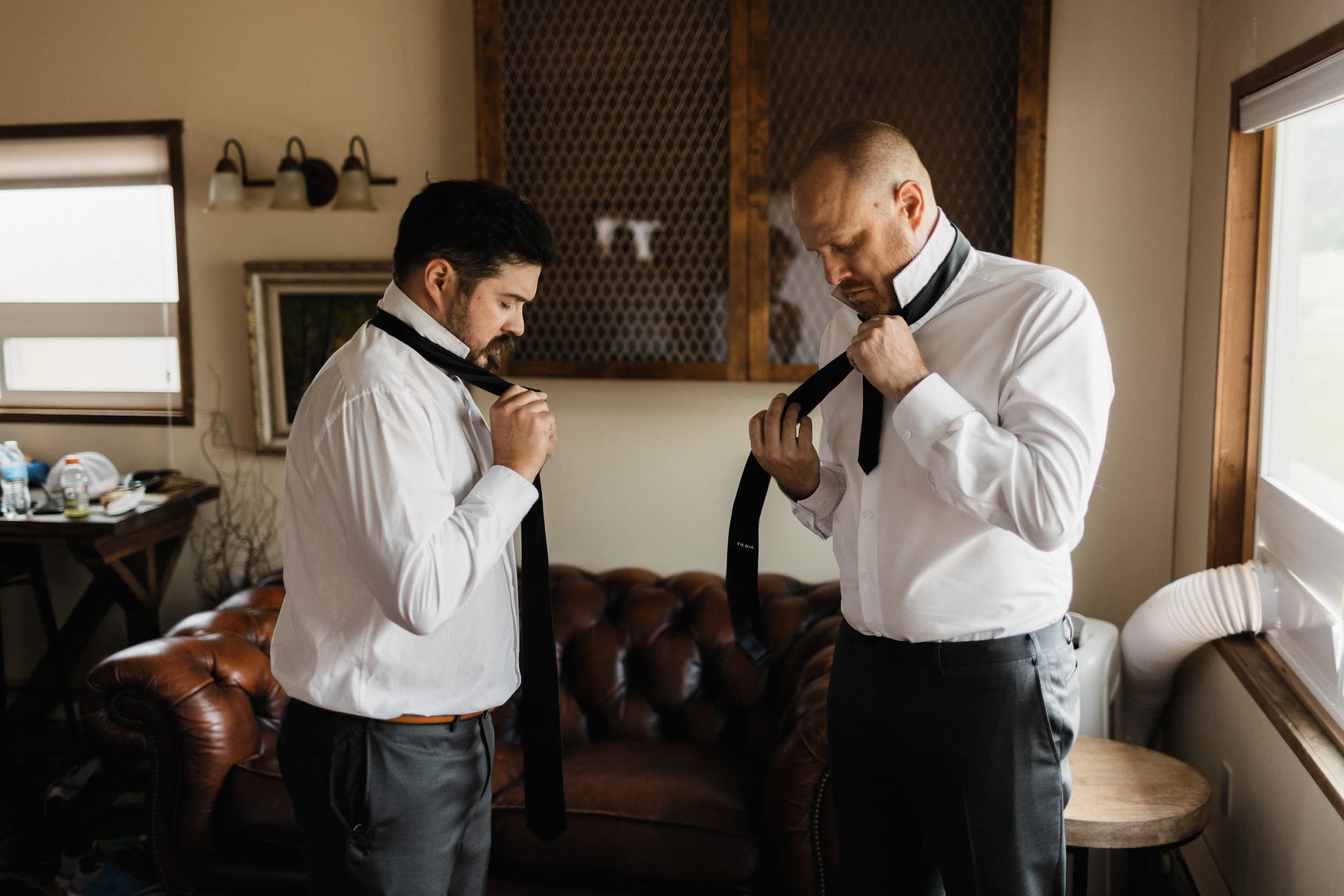 Groom and his best man putting their ties on