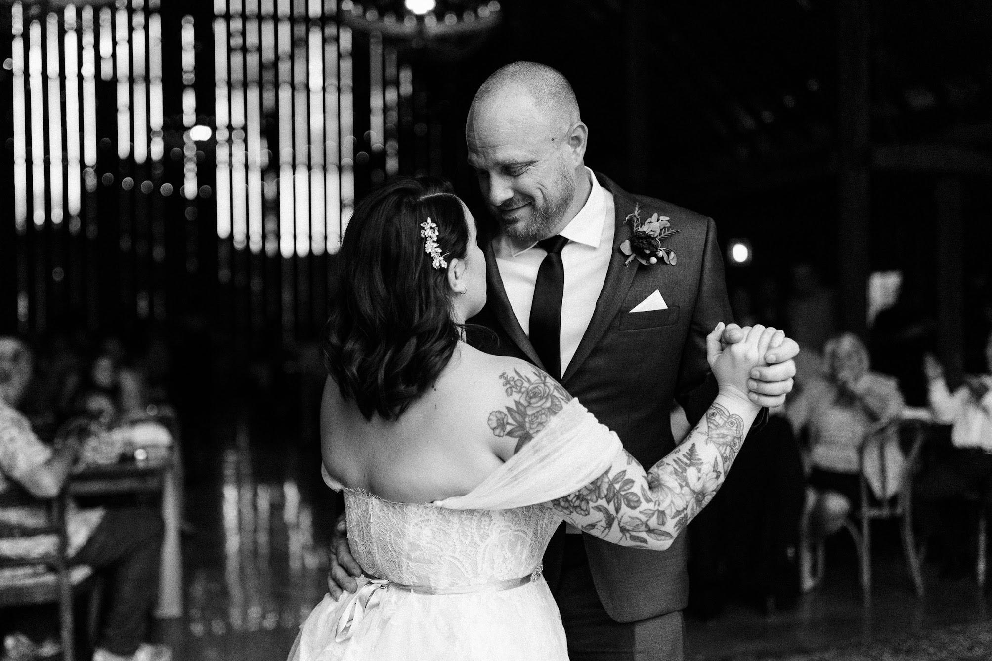 A black and white photo of the bride and groom sharing a first dance together.