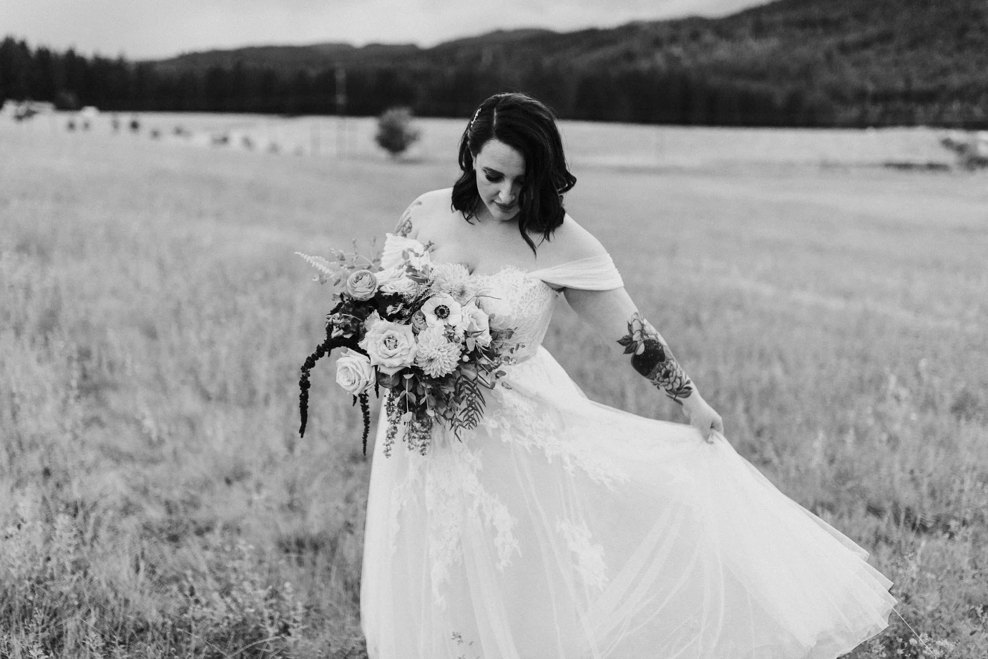 She is holding her wedding dress with one hand and looking at her flowers, it looks like she is dancing. 