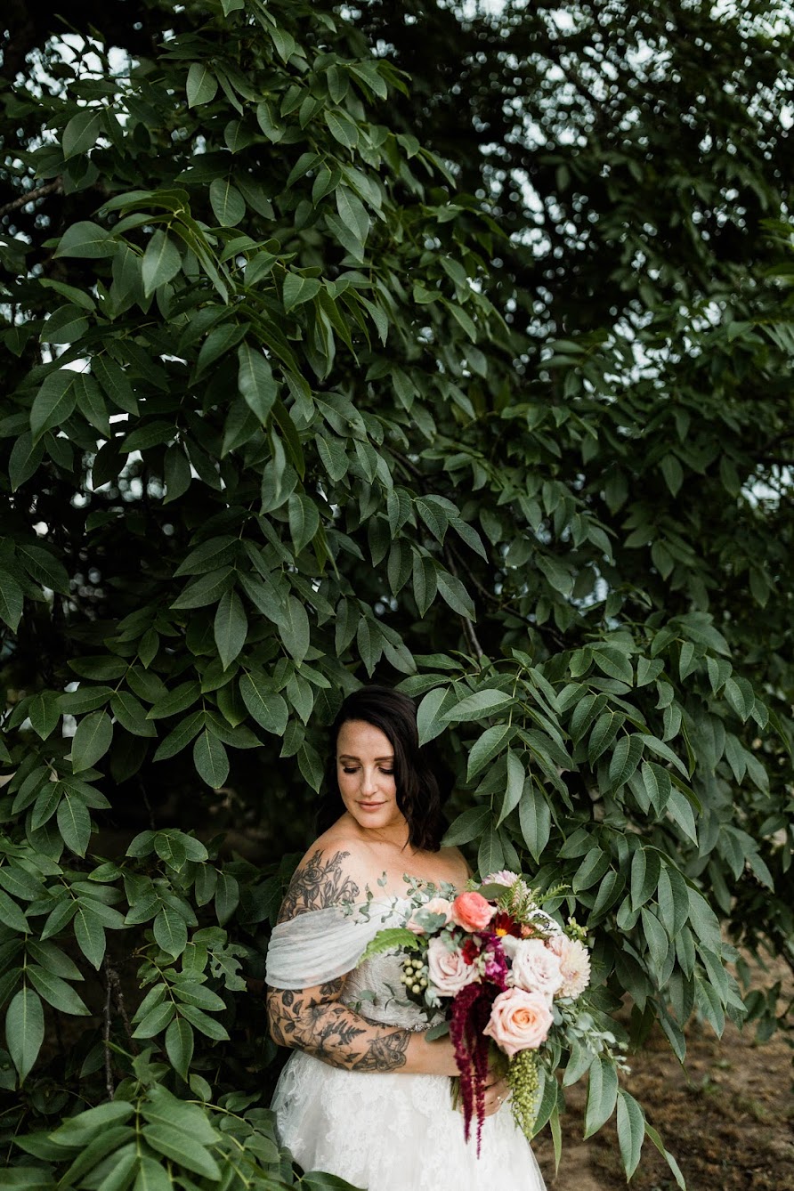 Sitting in a large tree with leaves all around the bride