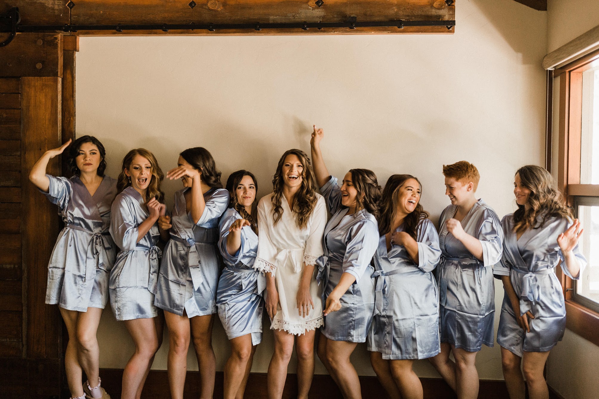 bride and her 8 bridesmaids in robes all-dancing. 