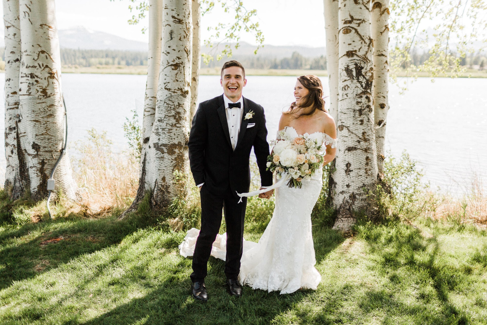 bride and groom with aspen trees behind them and a lake 